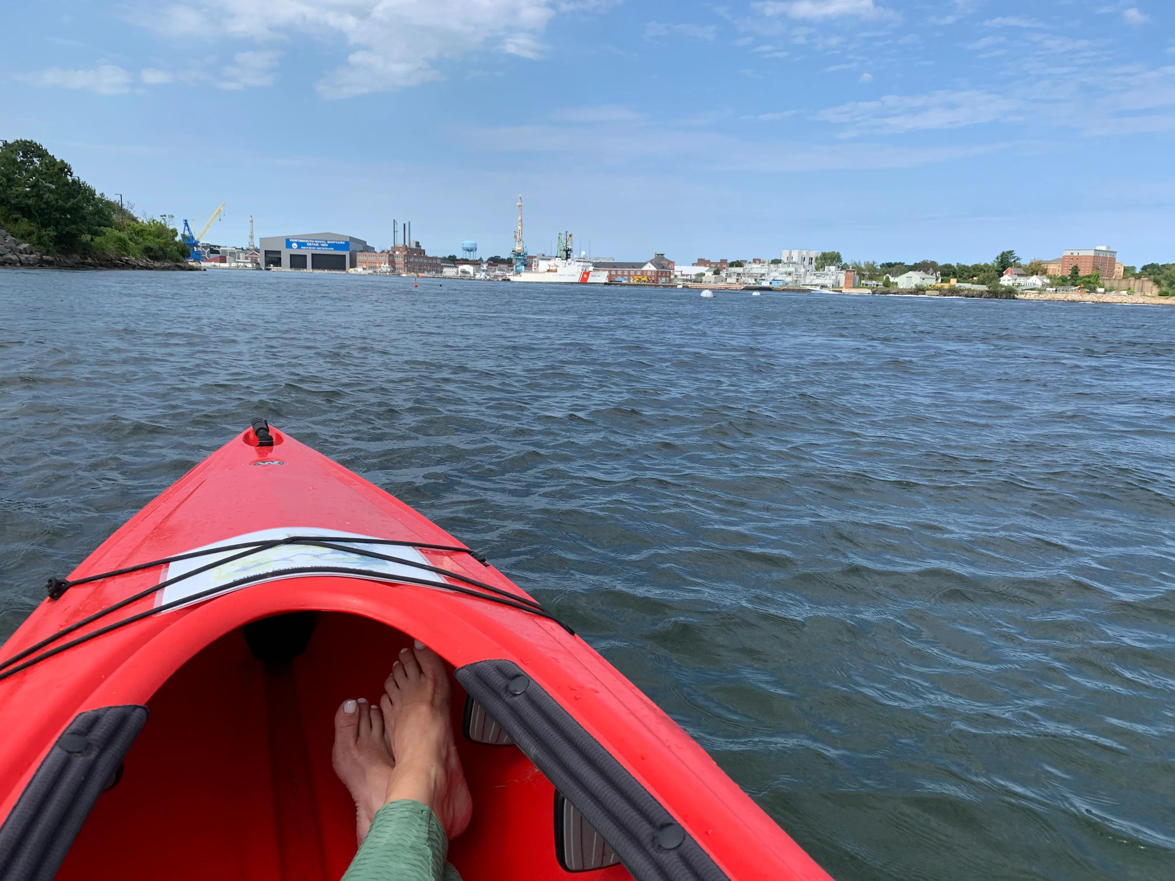 Rebecca's feet in a kayak on the water.