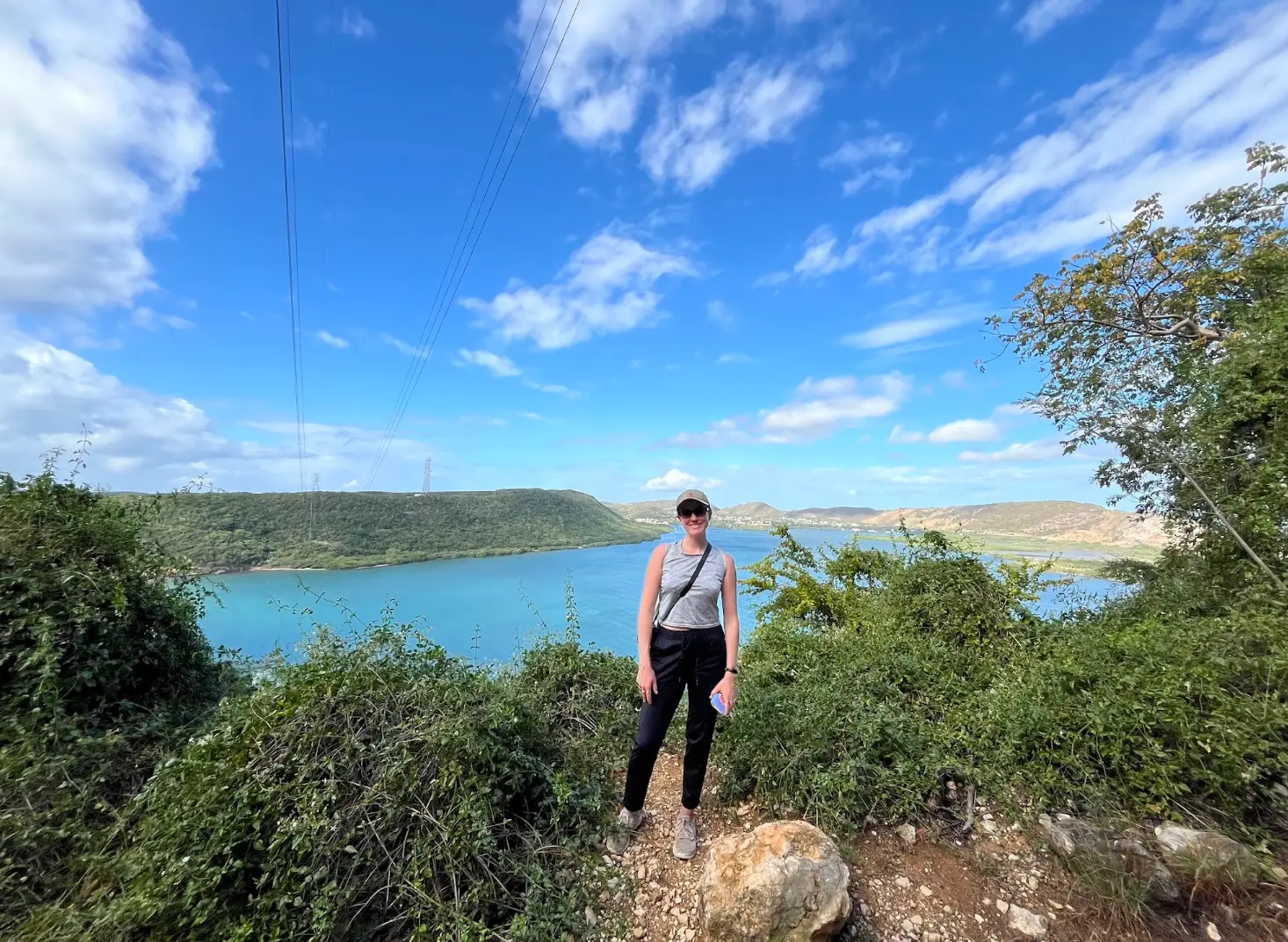 The writer stands in front of a blue body of water in Puerto Rico.