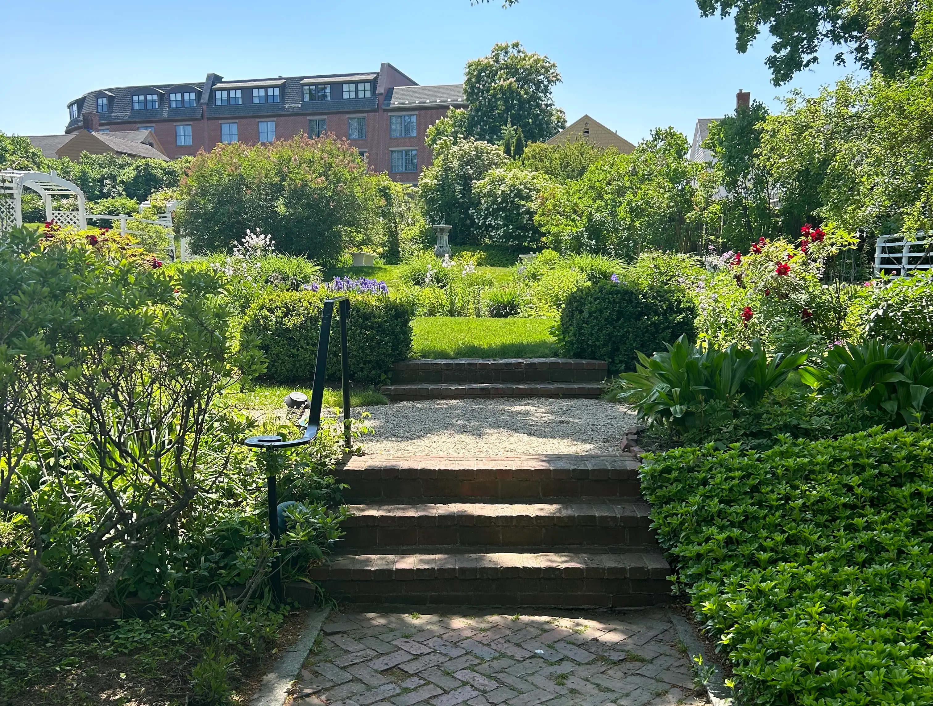 A well-manicured garden with buildings in the background.