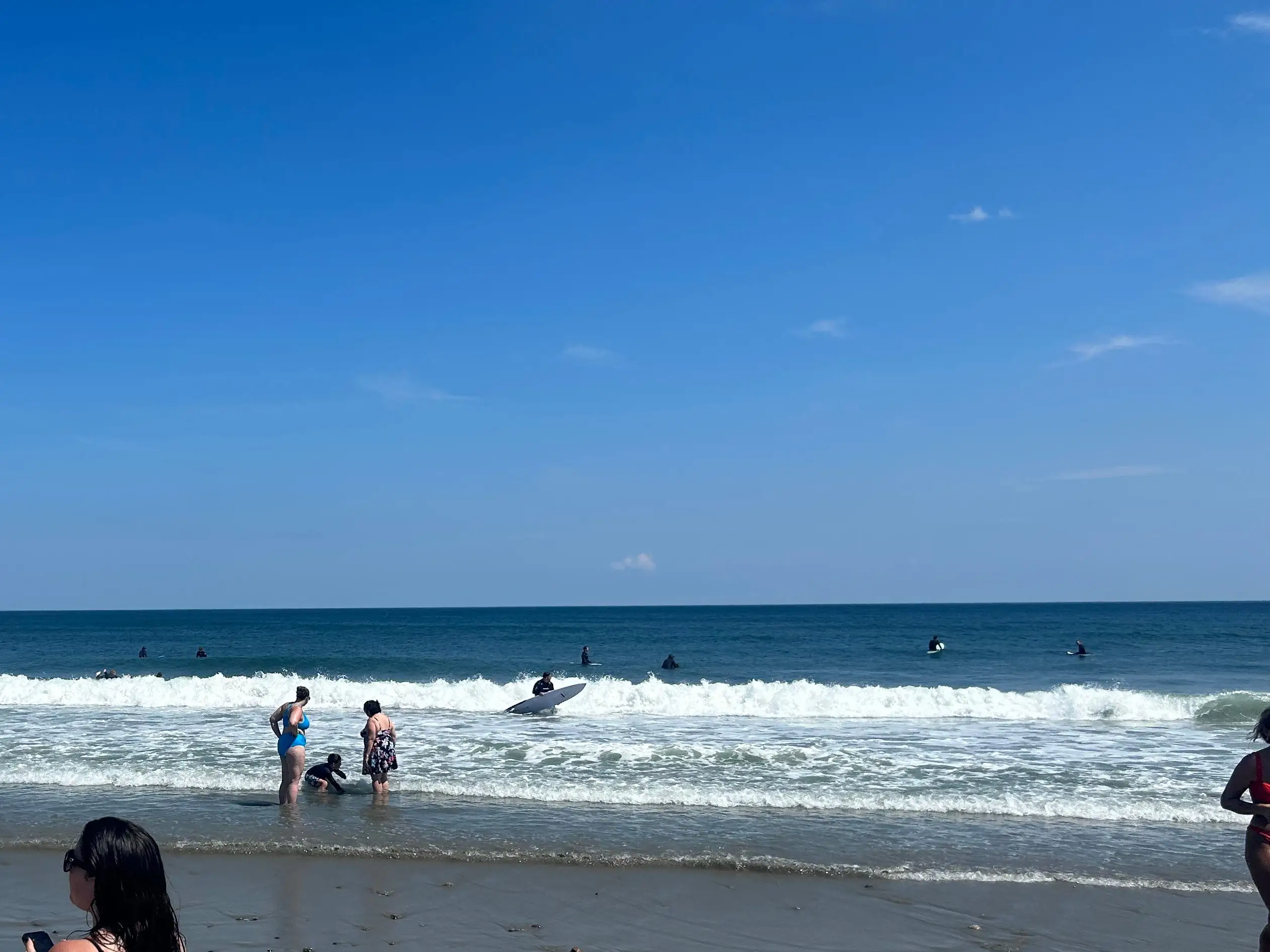 People in the ocean on a sunny day.