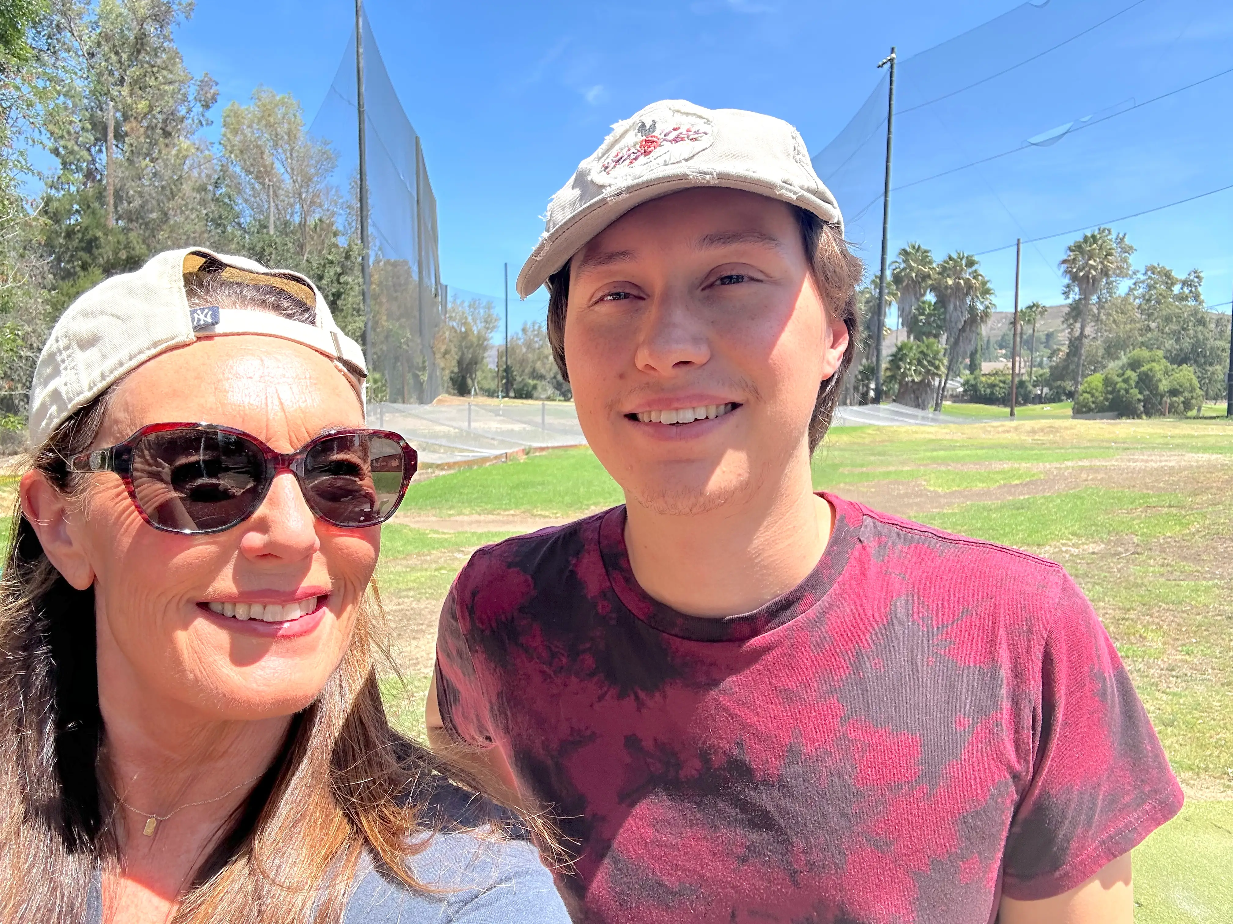 The author and her son are shown at a driving range on a sunny day.