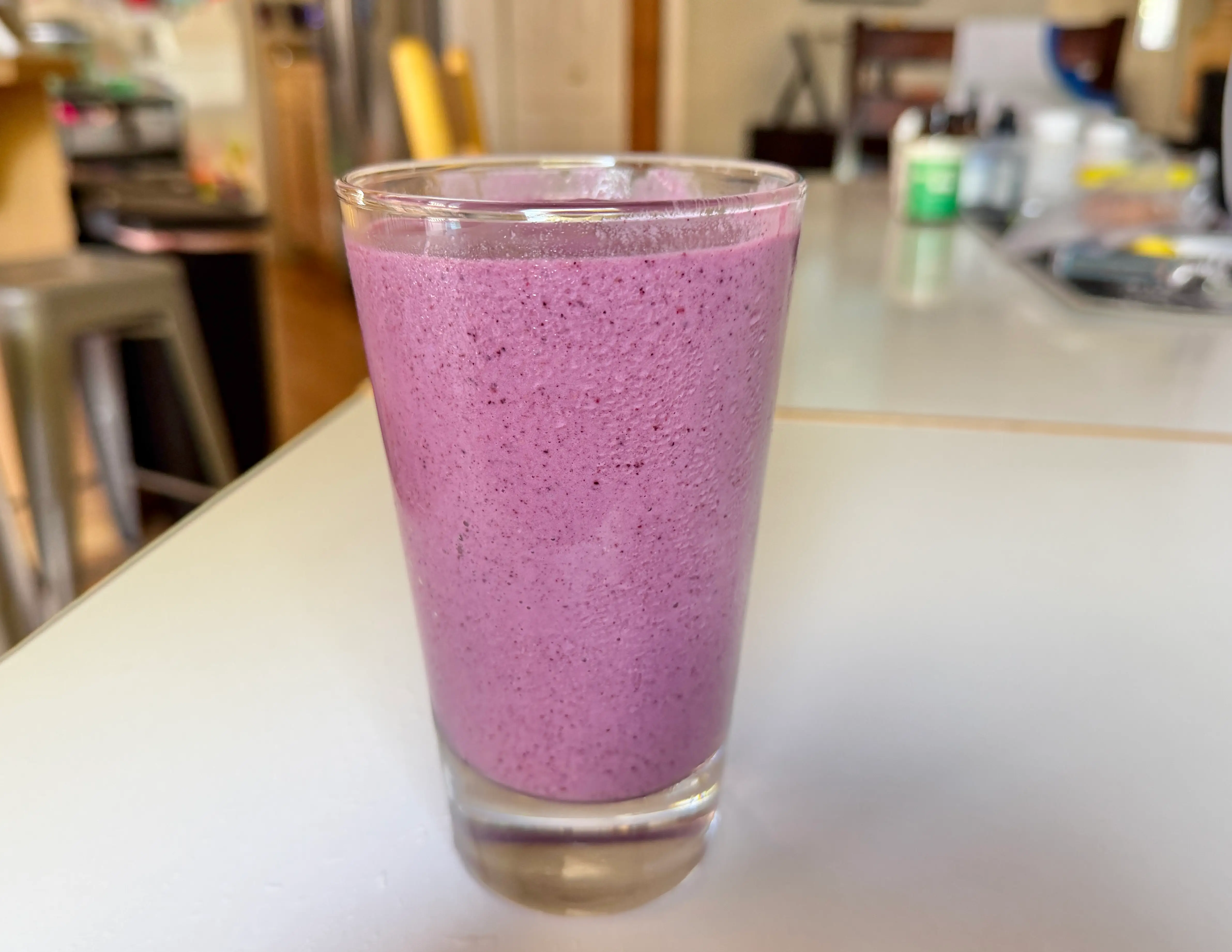 Purple-y pink smoothie in glass on counter