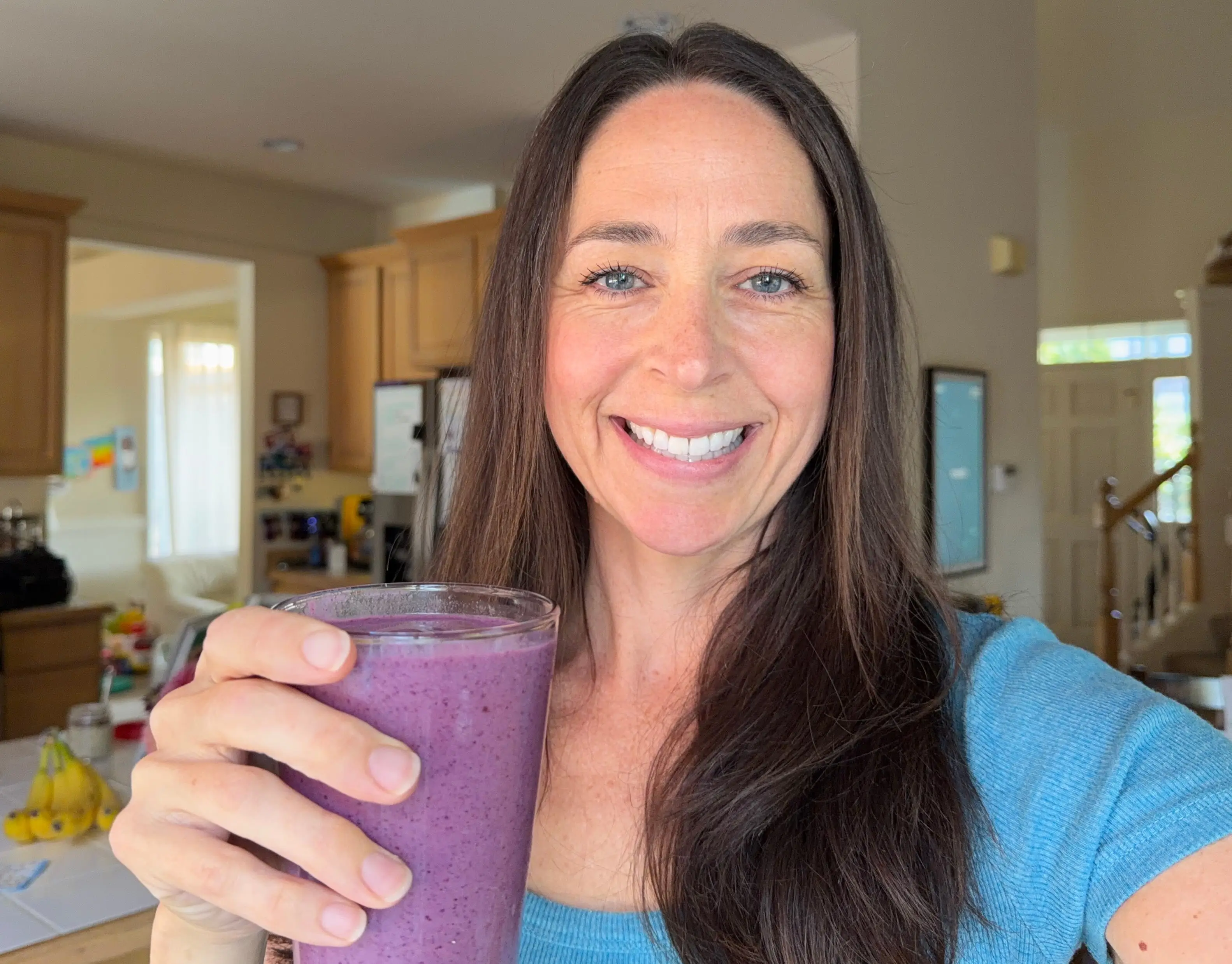 Woman smiling holding smoothie