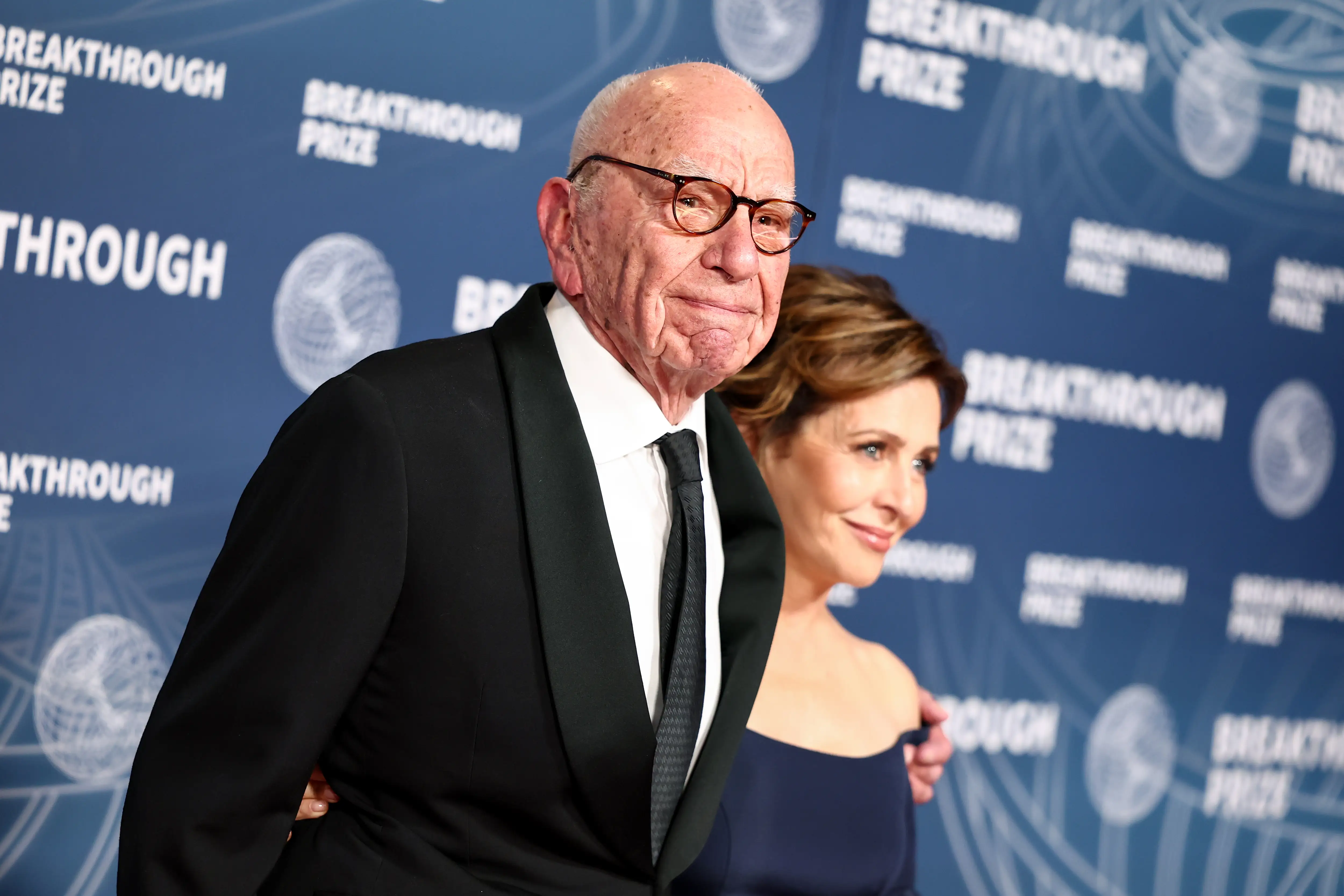Rupert Murdoch poses in formalwear with another attendee before a Breakthrough Prize backdrop.