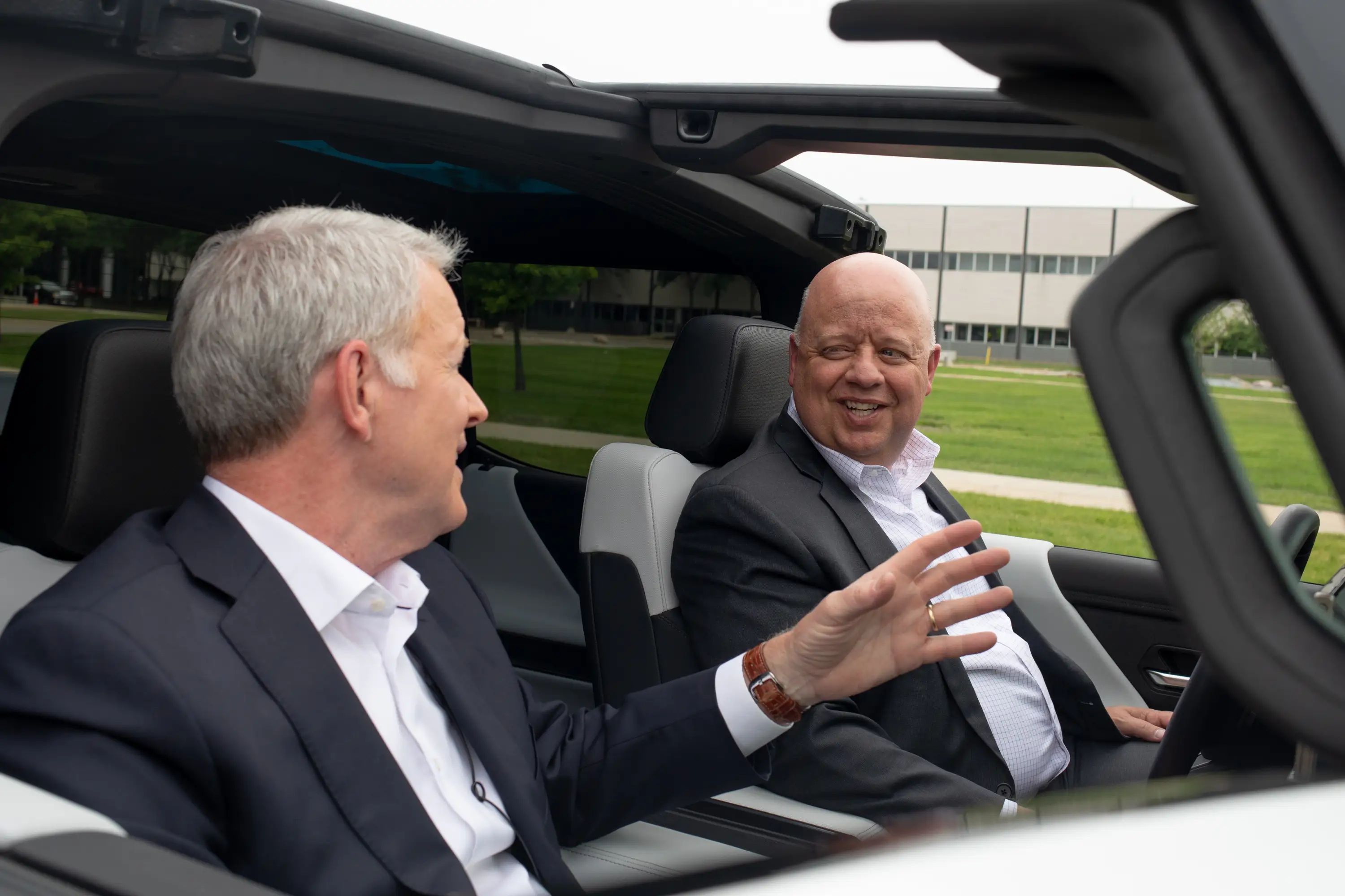 Paul Jacobson, on the right, sits in the driver's seat of a GMC Hummer EV.