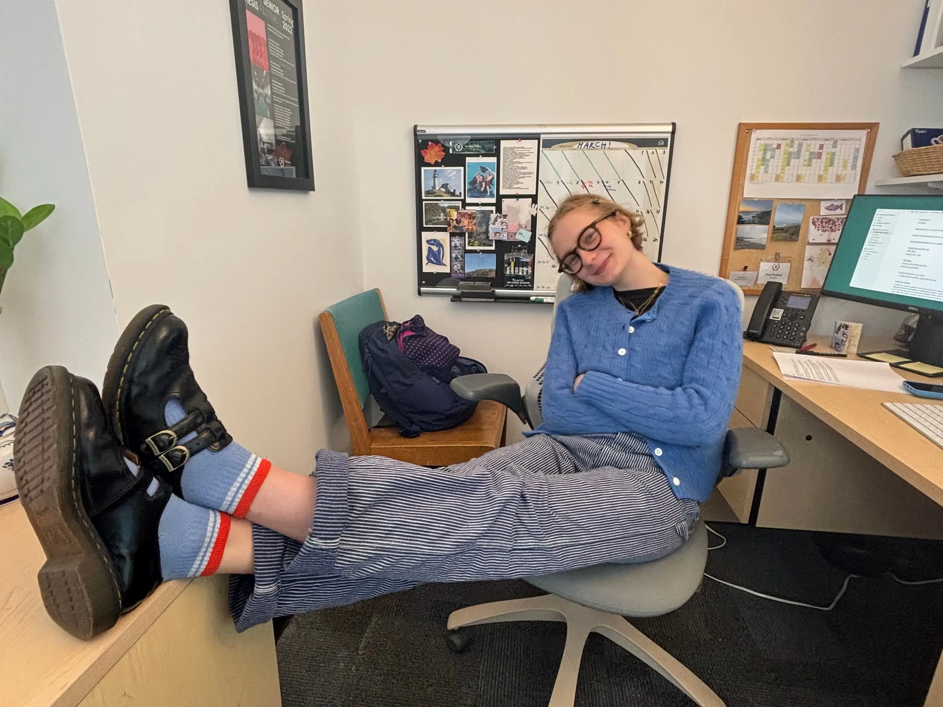 The writer is sitting at a desk with her feet propped up.