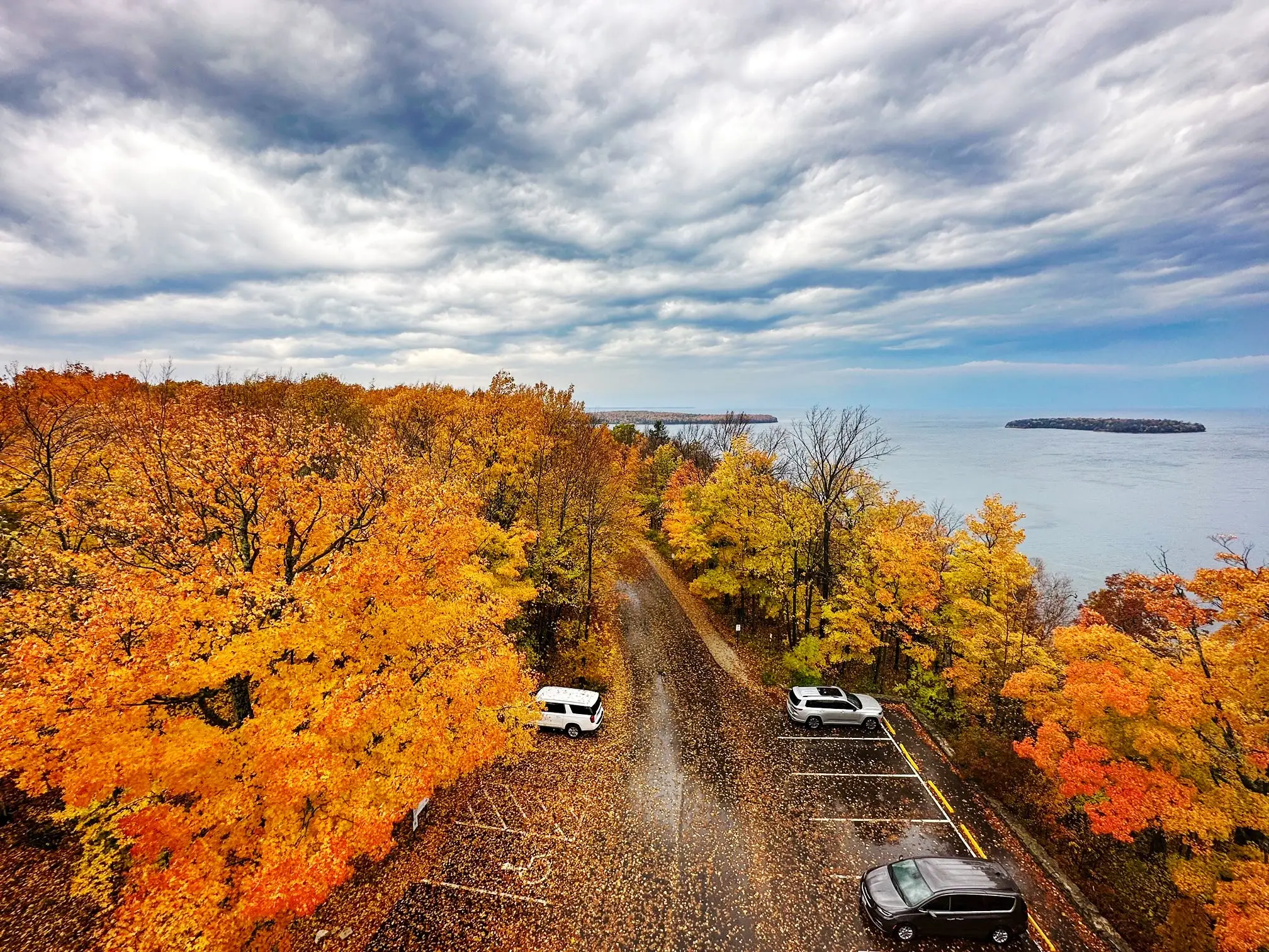 View of orange and yellow foliage from above at Peninsula State Park observation tower parking lot