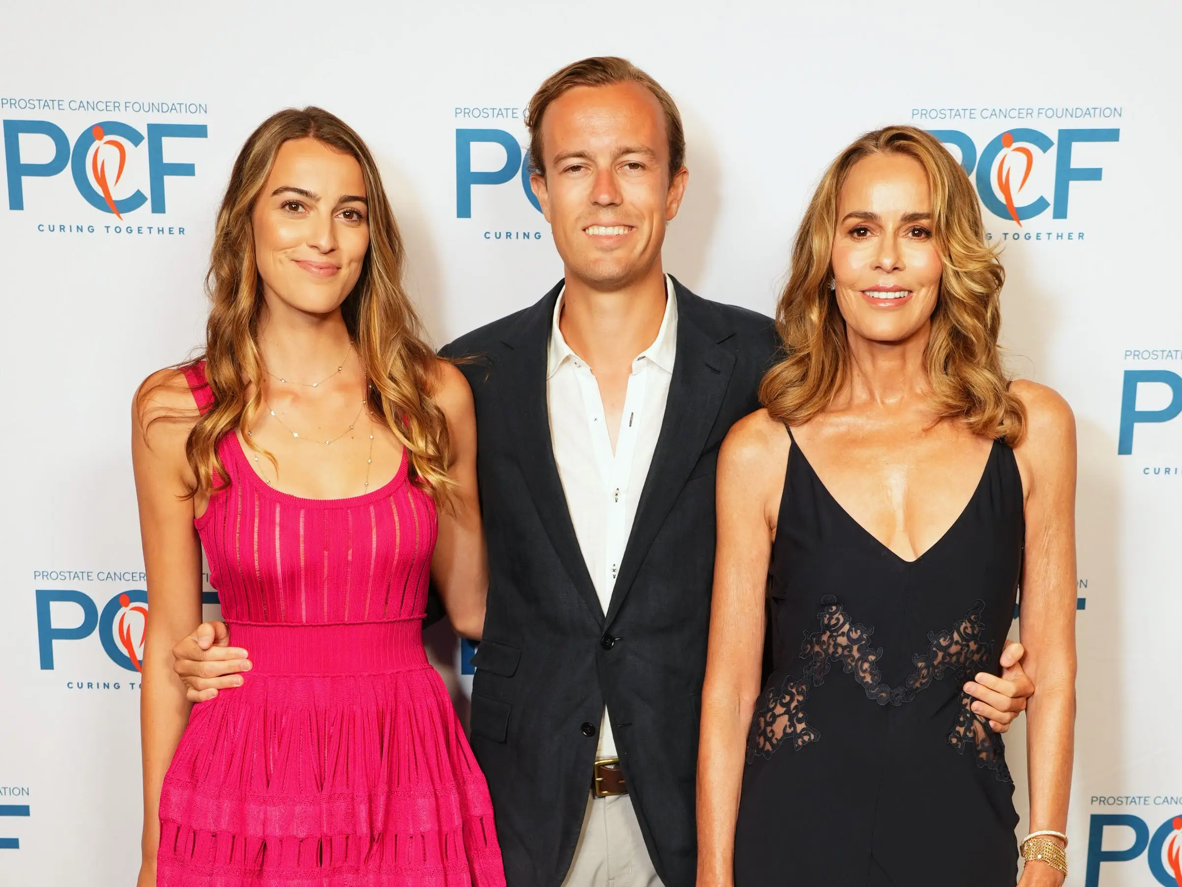 Three attendees pose together in front of a PFC Playing for Change Foundation step-and-repeat backdrop.