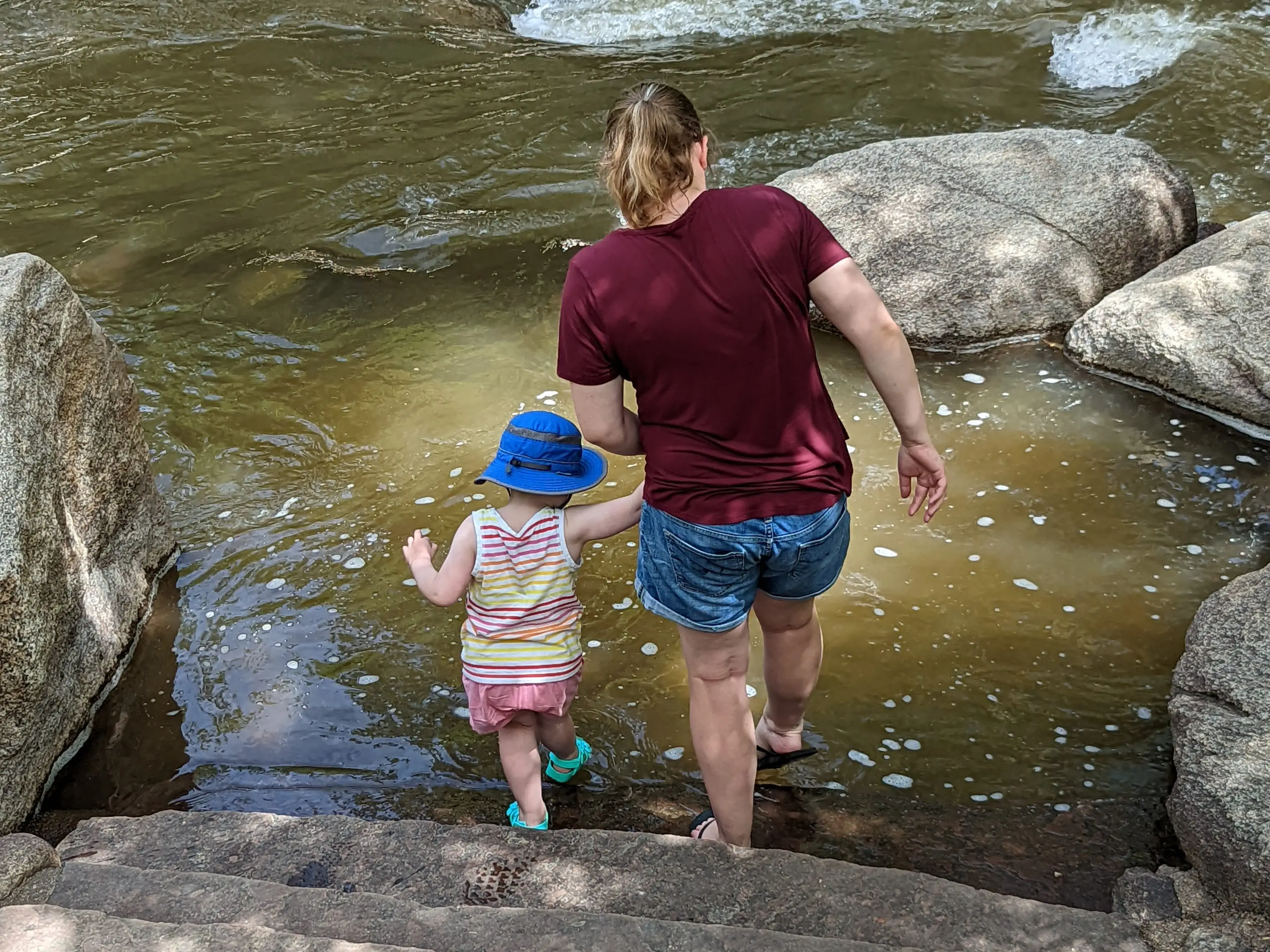 the author and her daughter walking into a creek