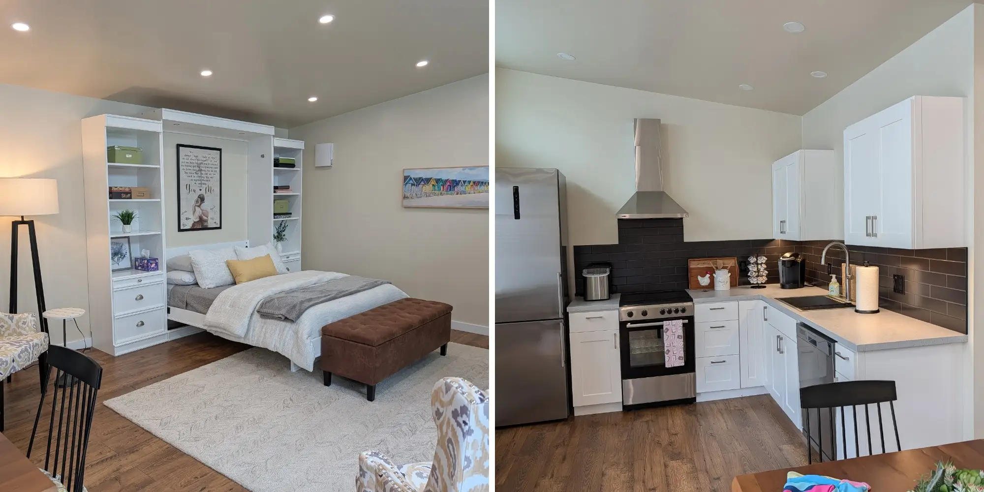 Studio interior with a wall bed and seating area beside a compact kitchen with white cabinets and stainless appliances.