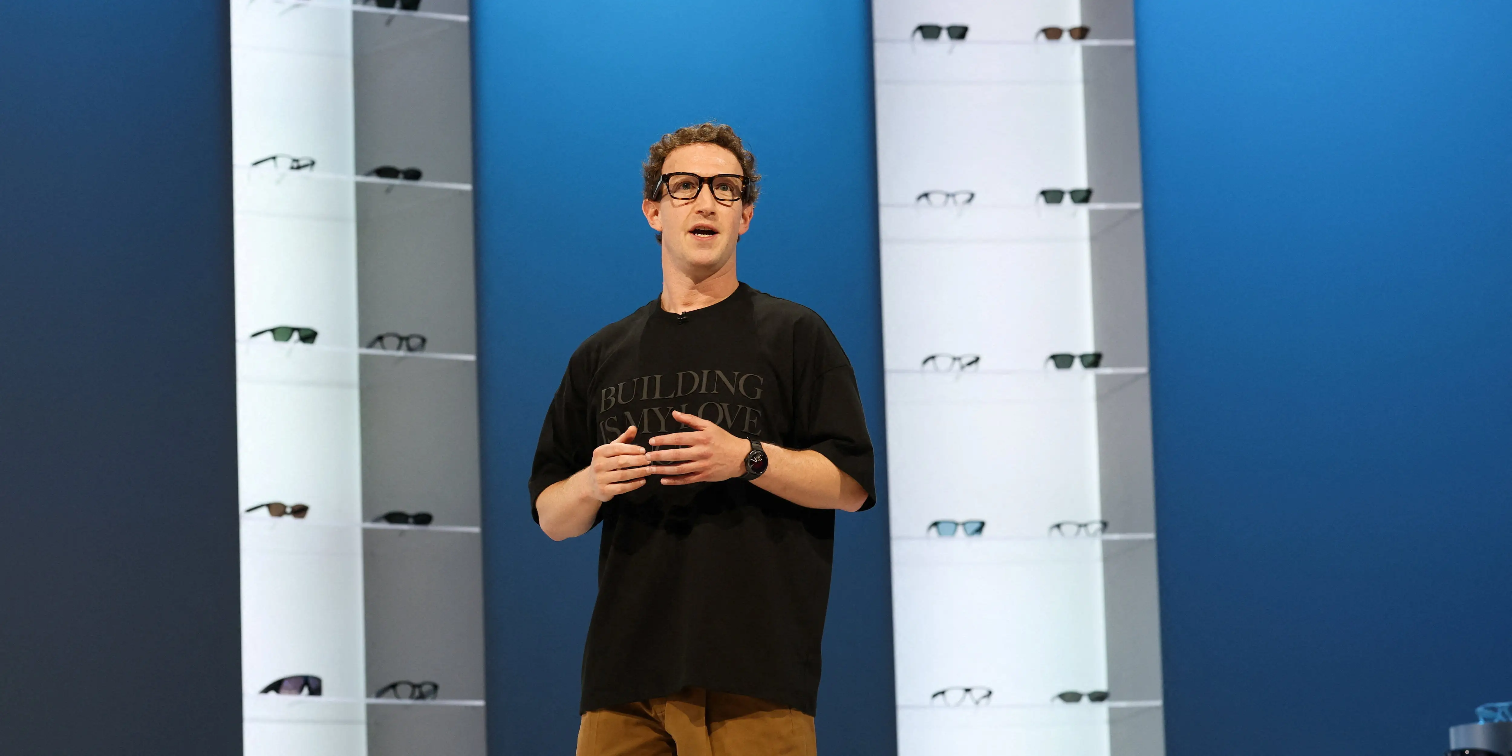 Mark Zuckerberg in front of a wall of glasses.