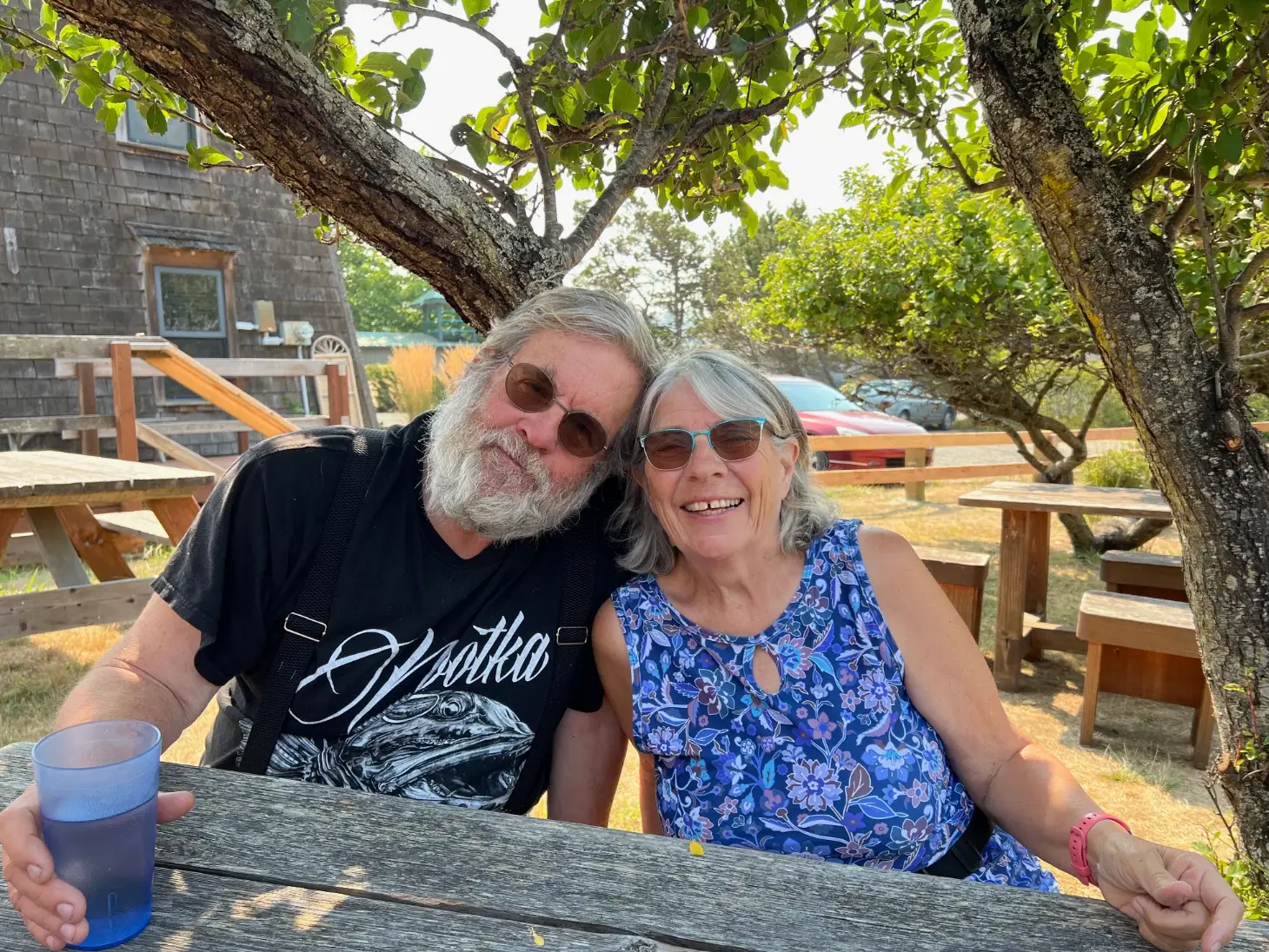 The author's parents smile while sitting at a picnic table in Washington state.