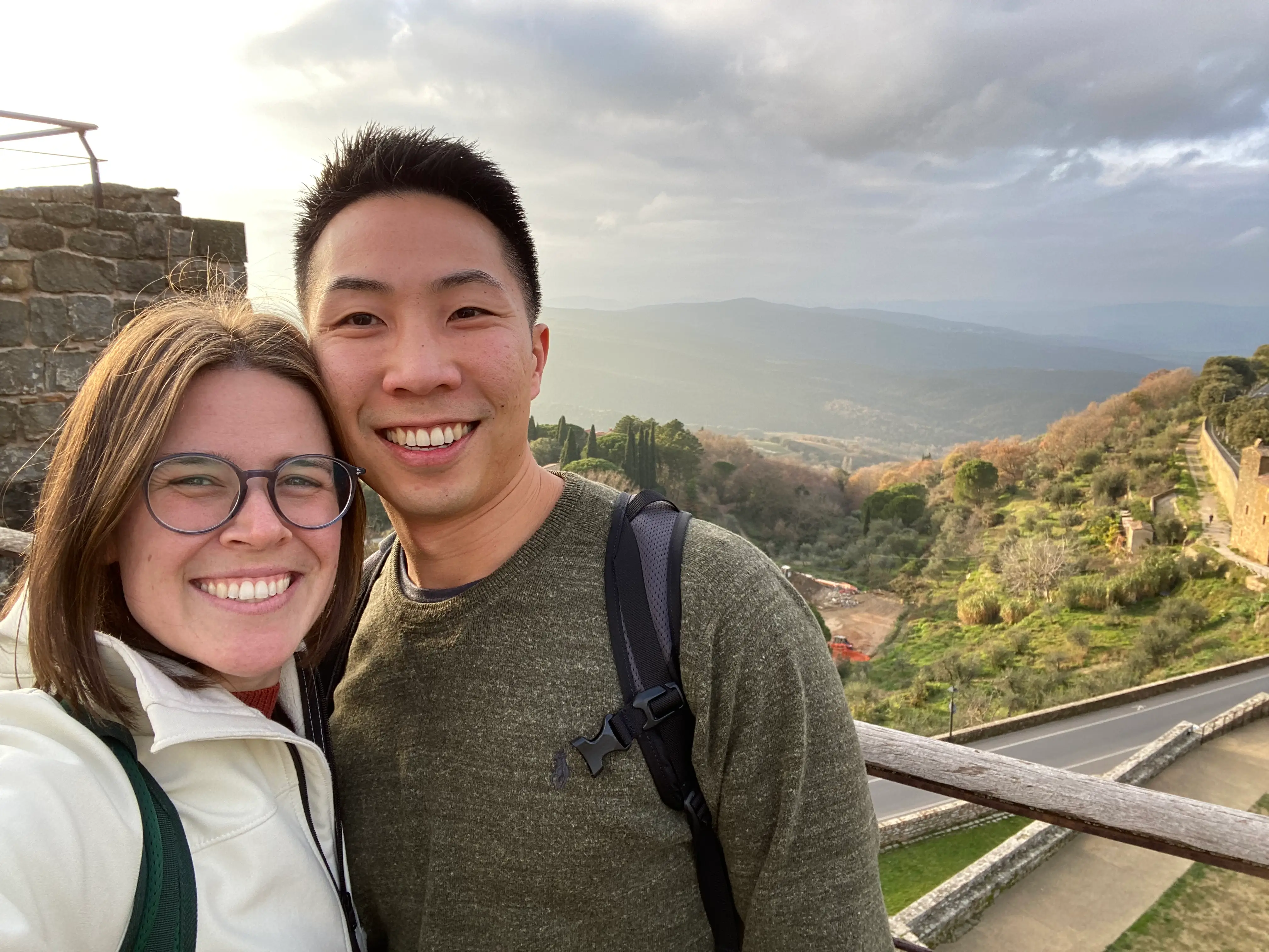 The writer and her husband smiling side by side, with a beautiful mountainous backdrop.