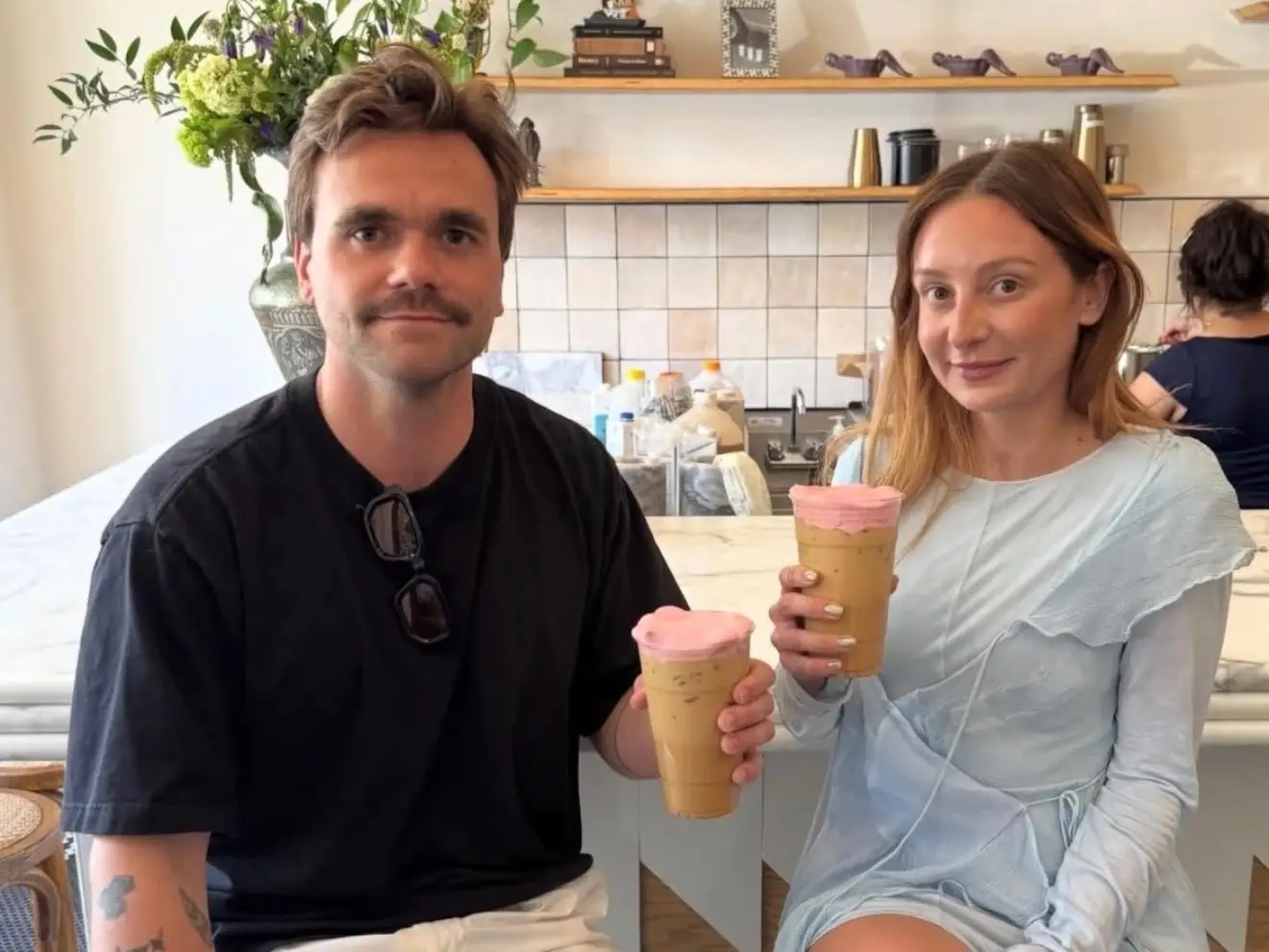 a couple holds two coffees