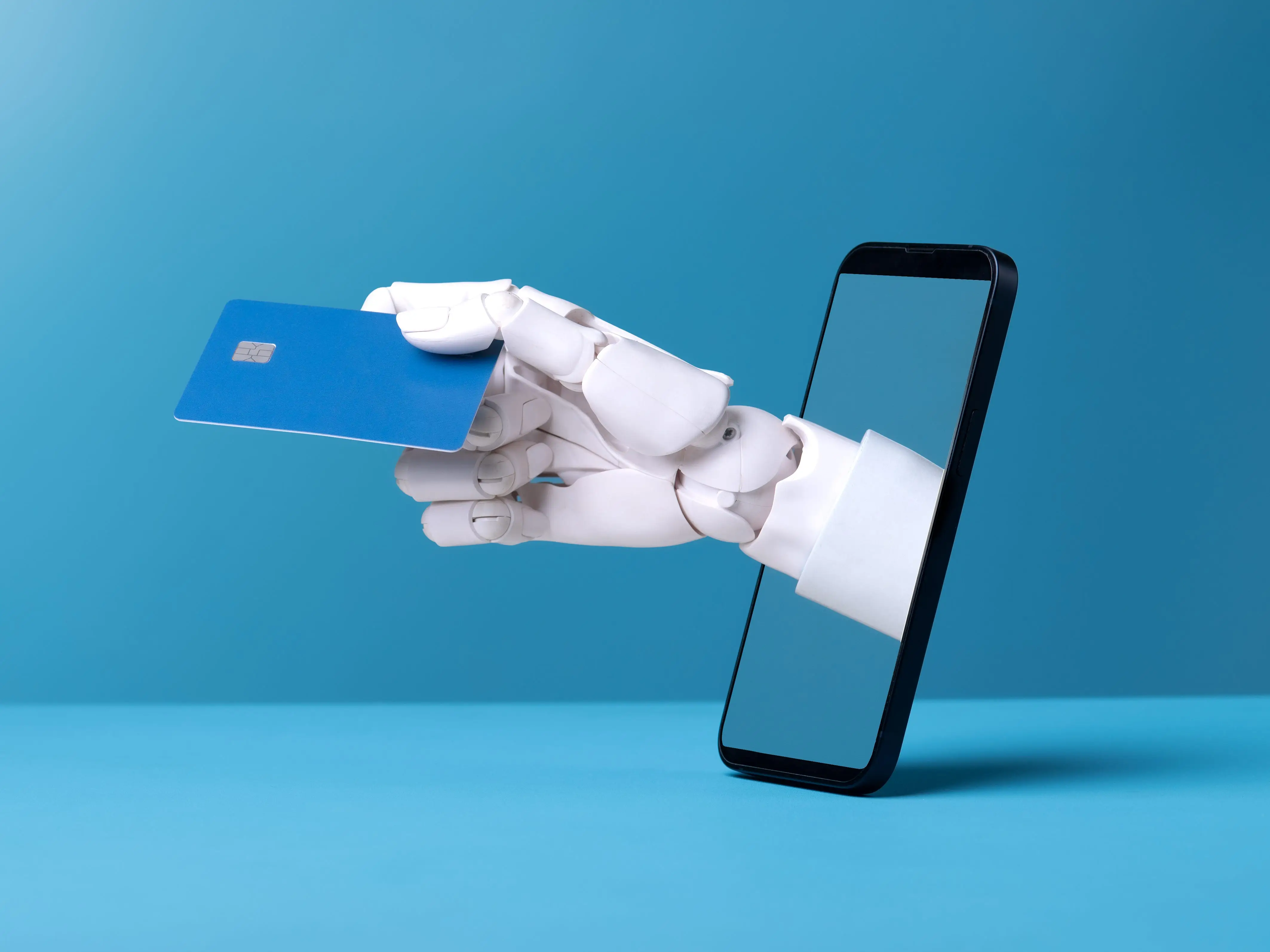 A robot hand holding a credit card