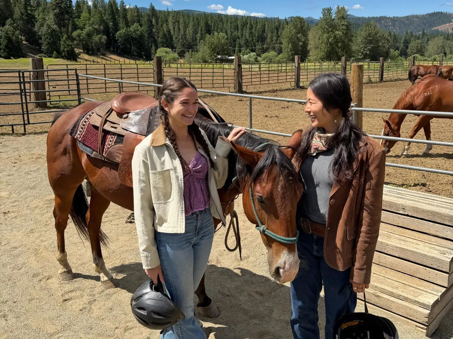 Anna and Ellie smile at each other while petting a horse.