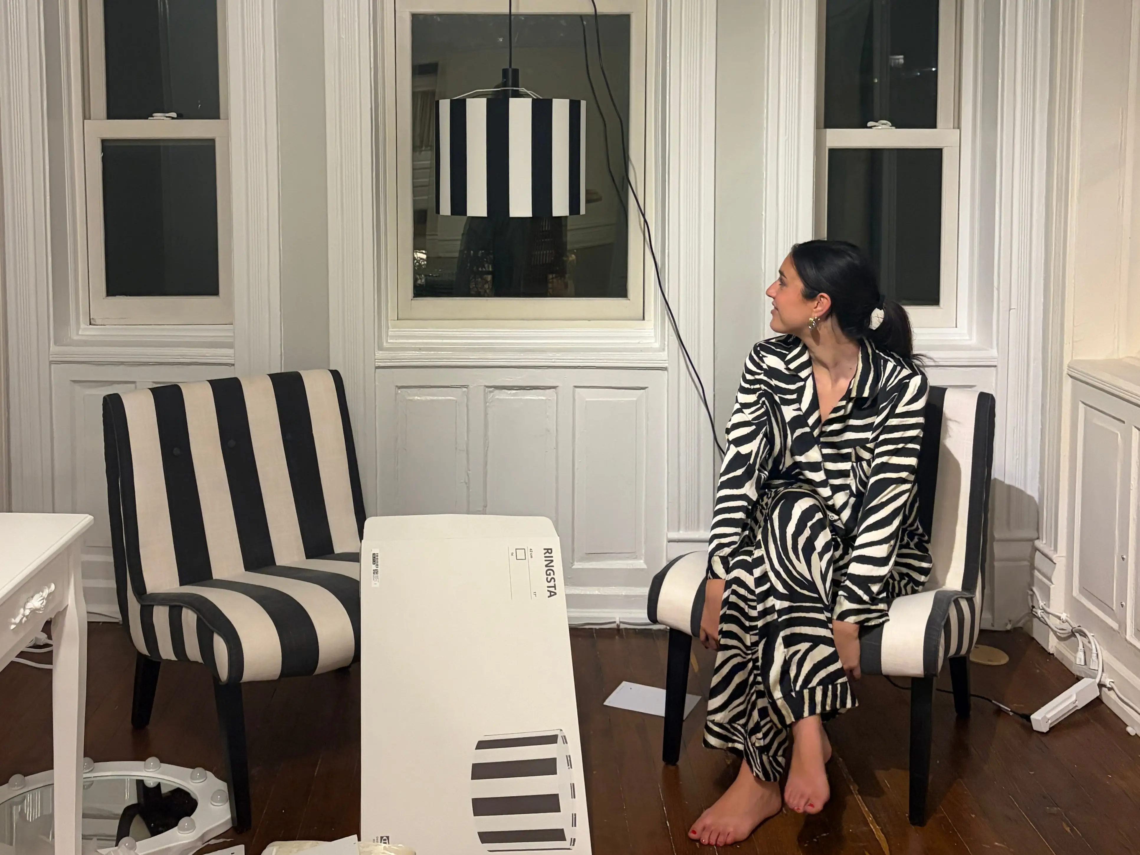 The writer is sitting on a chair in her new apartment in Chicago.