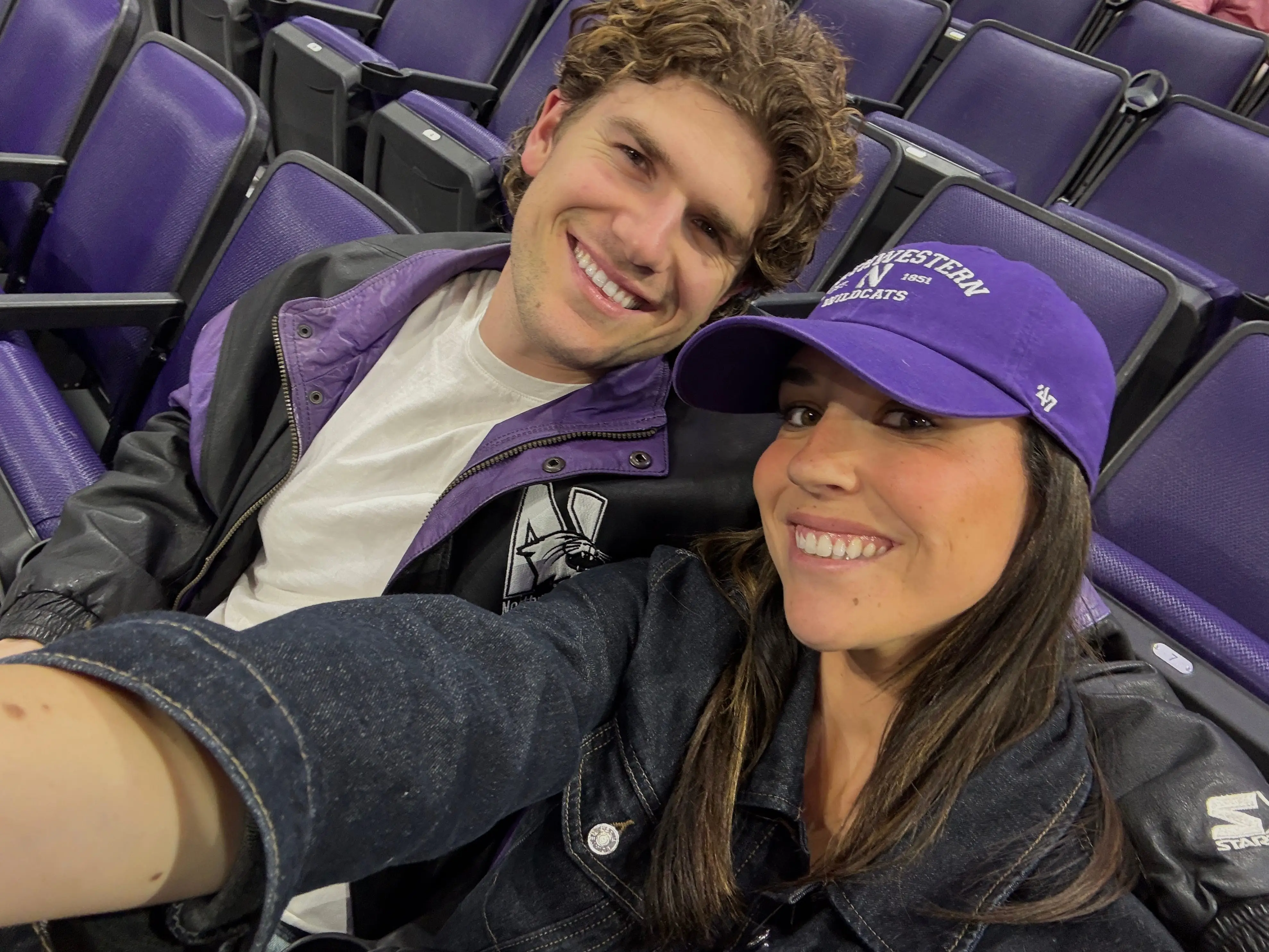 The writer and her boyfriend are posing for a selfie at a Northwestern basketball game.