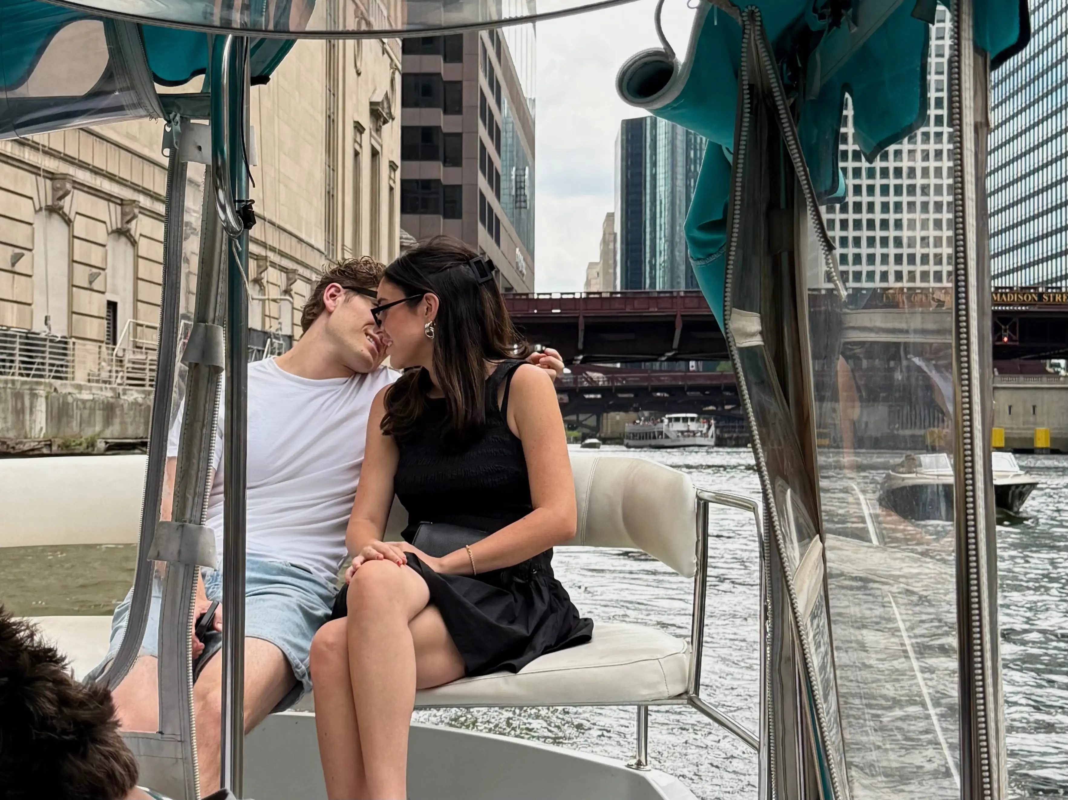 The writer and her boyfriend sit side by side while riding a Duffy boat along the Chicago River.