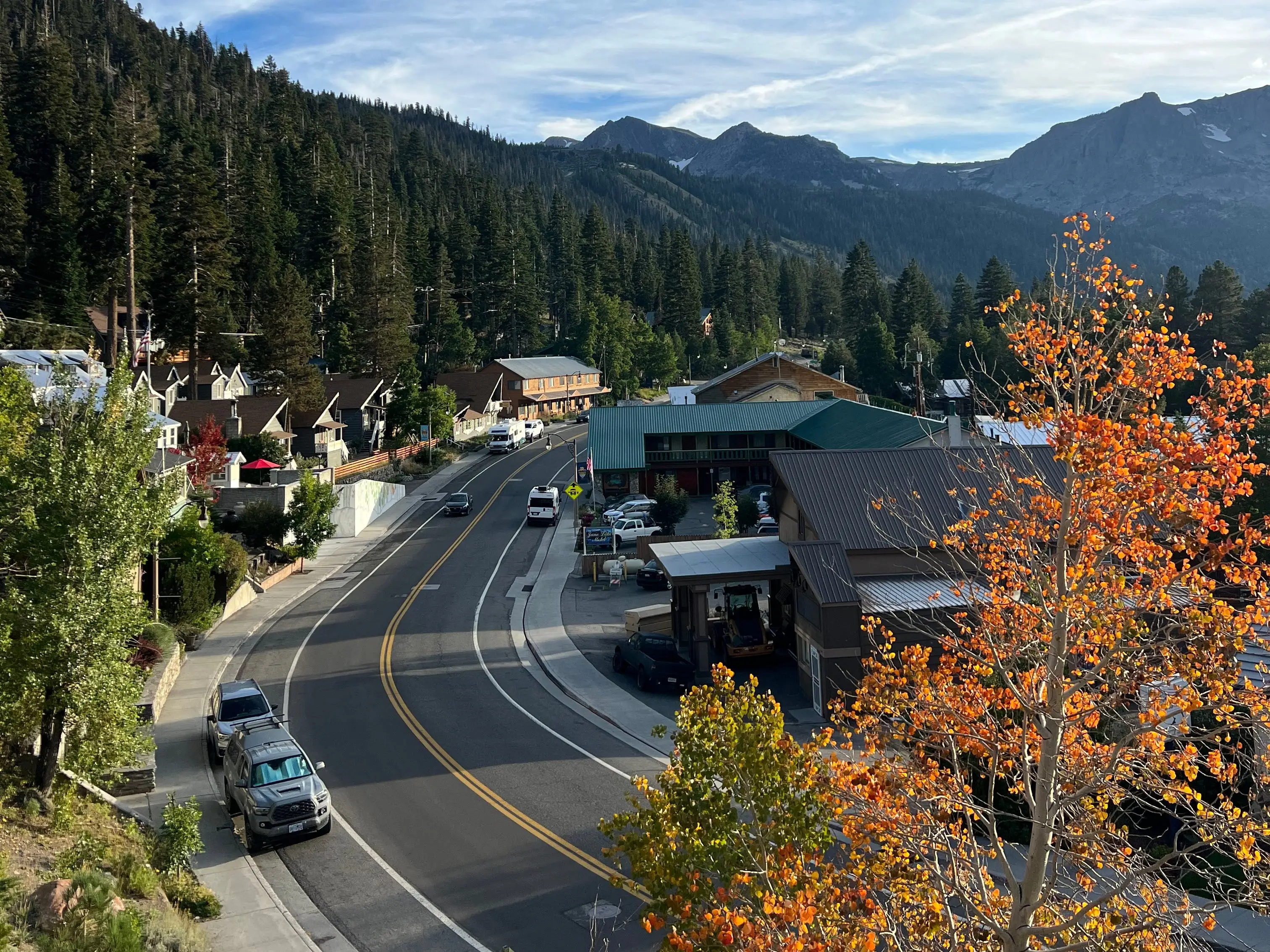 A road passes through a mountain town on a fall day.