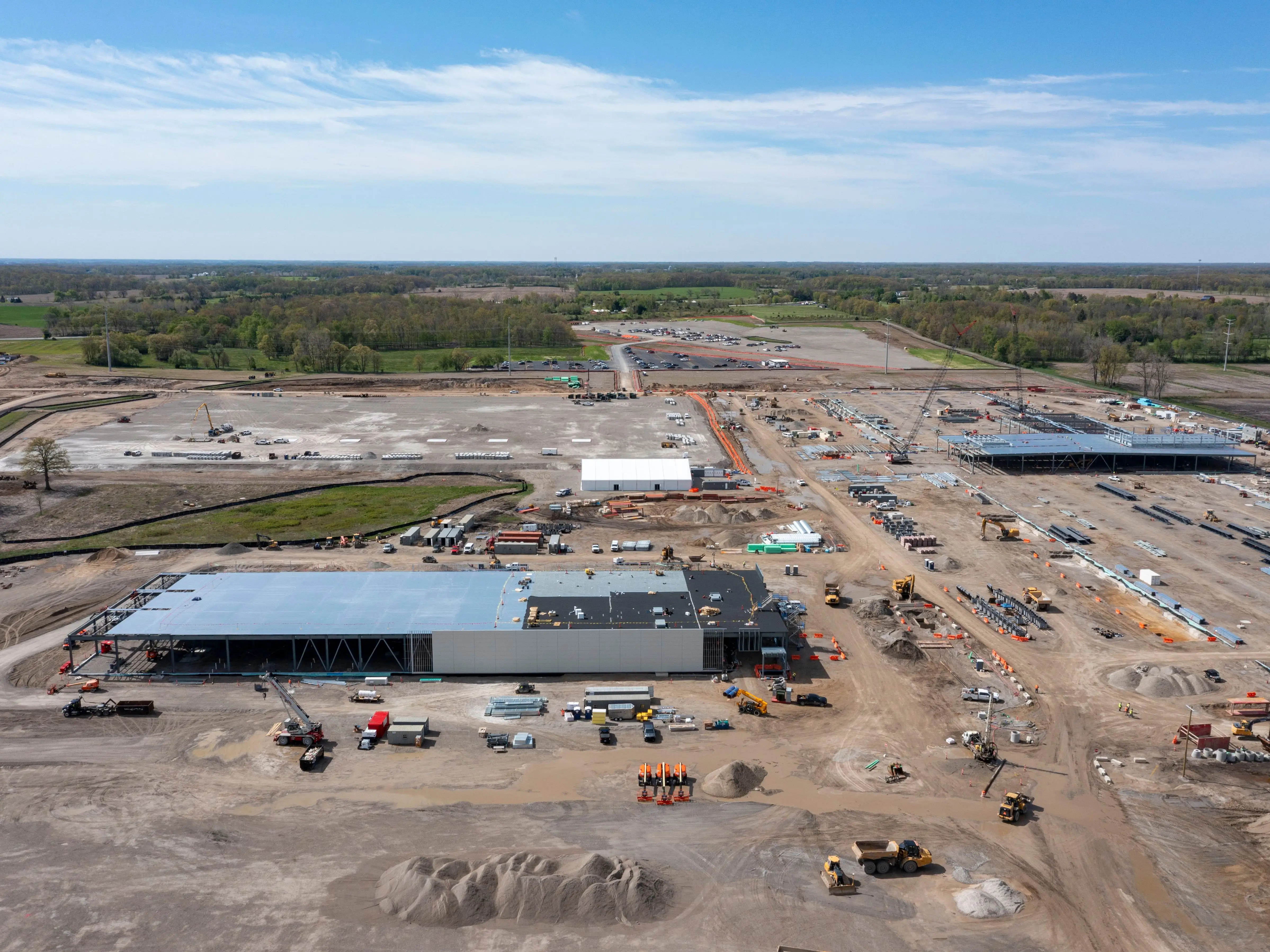 a massive building under construction, surrounded by dirt