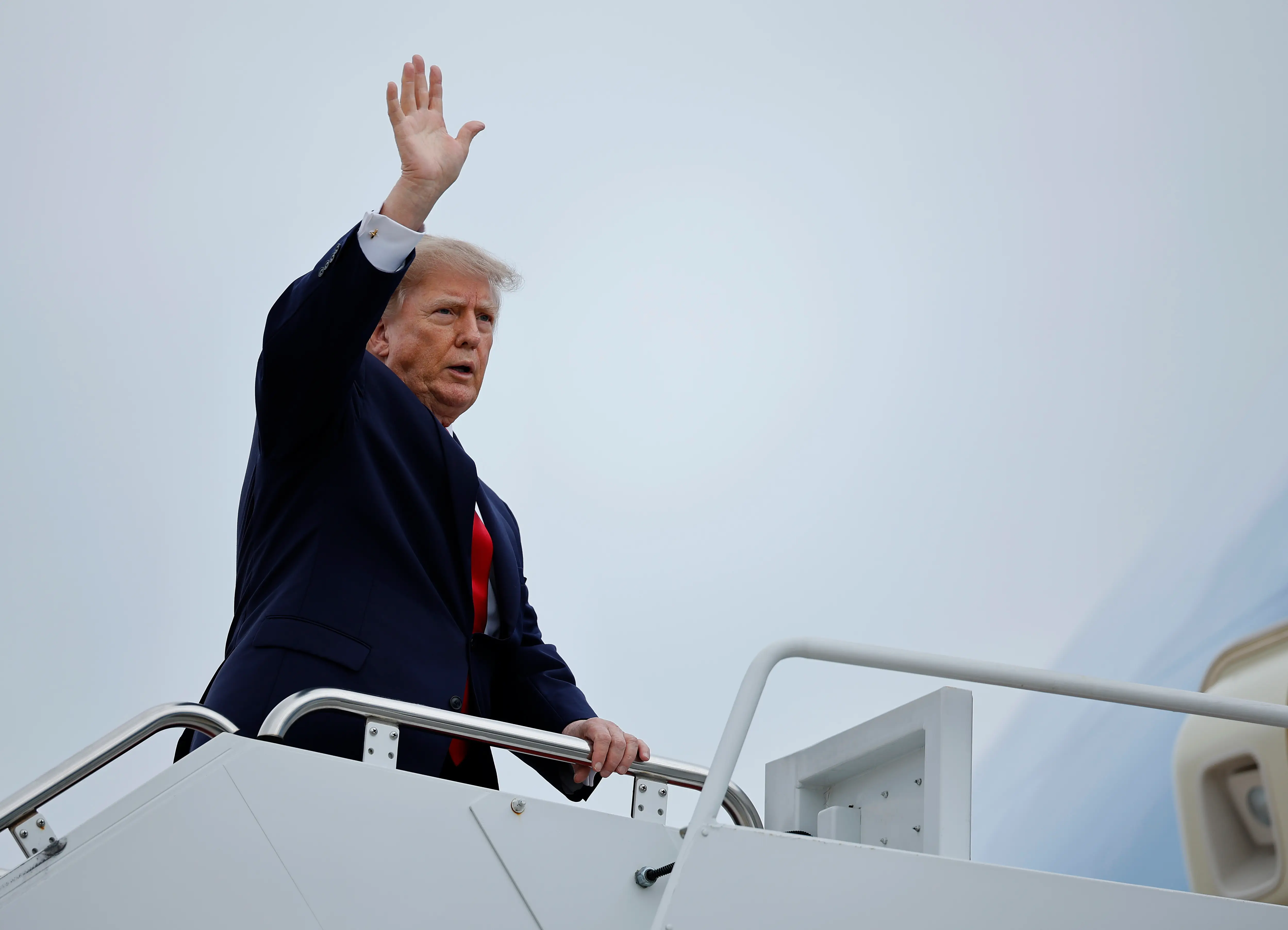 President Donald Trump waves as he boards Air Force One.