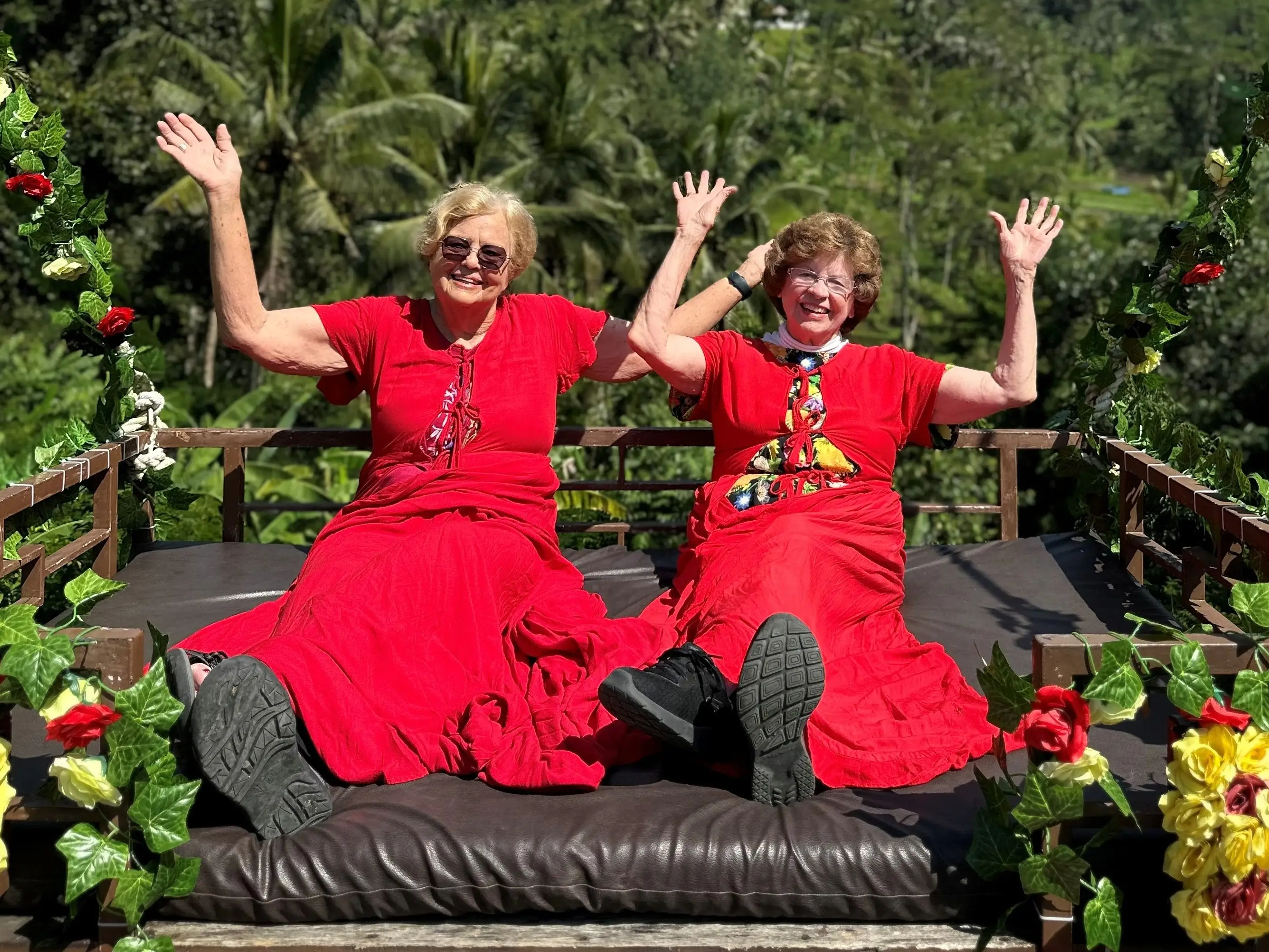 The writers, wearing matching red outfits, wave from