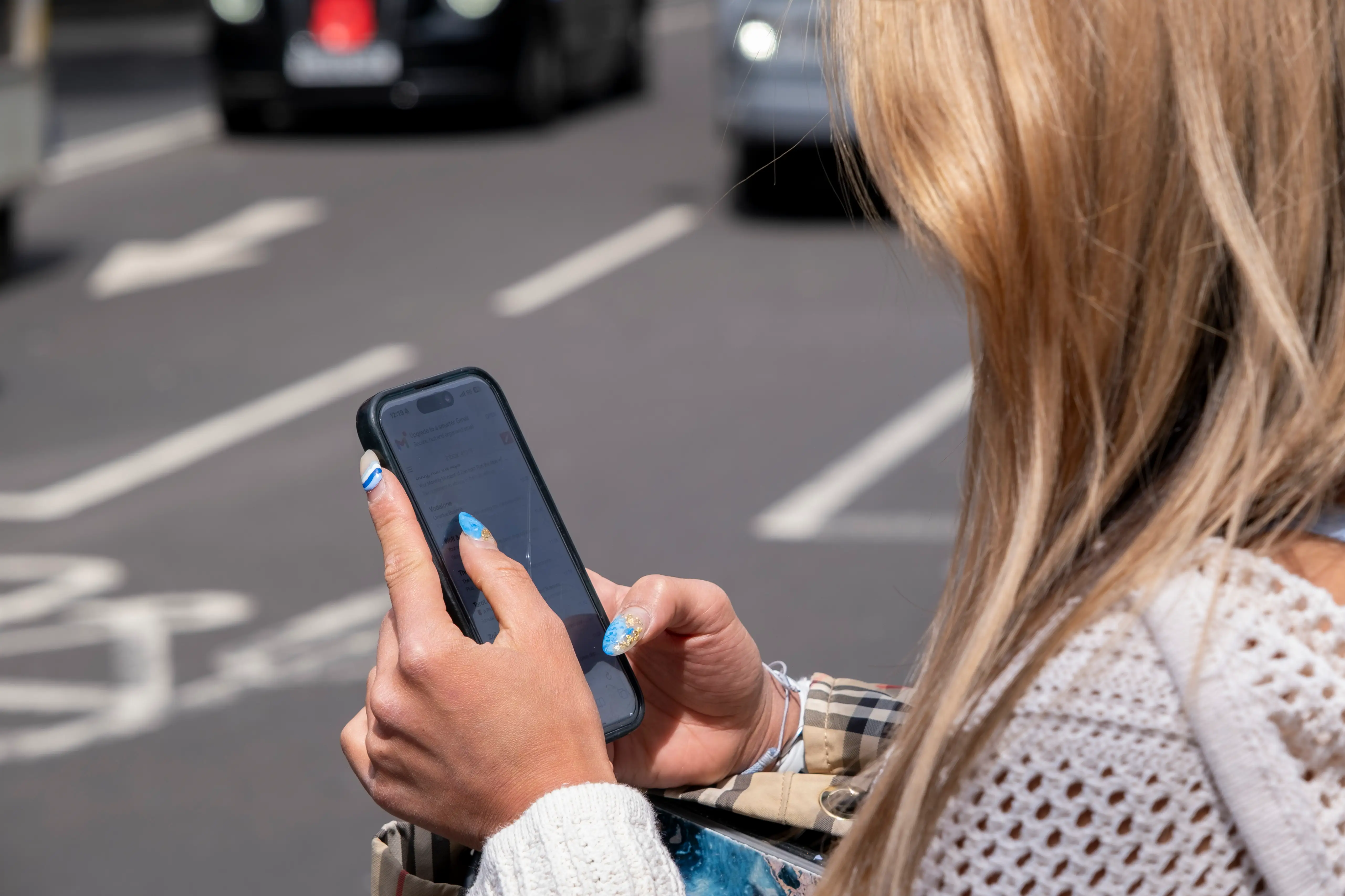 A woman looks at her smartphone