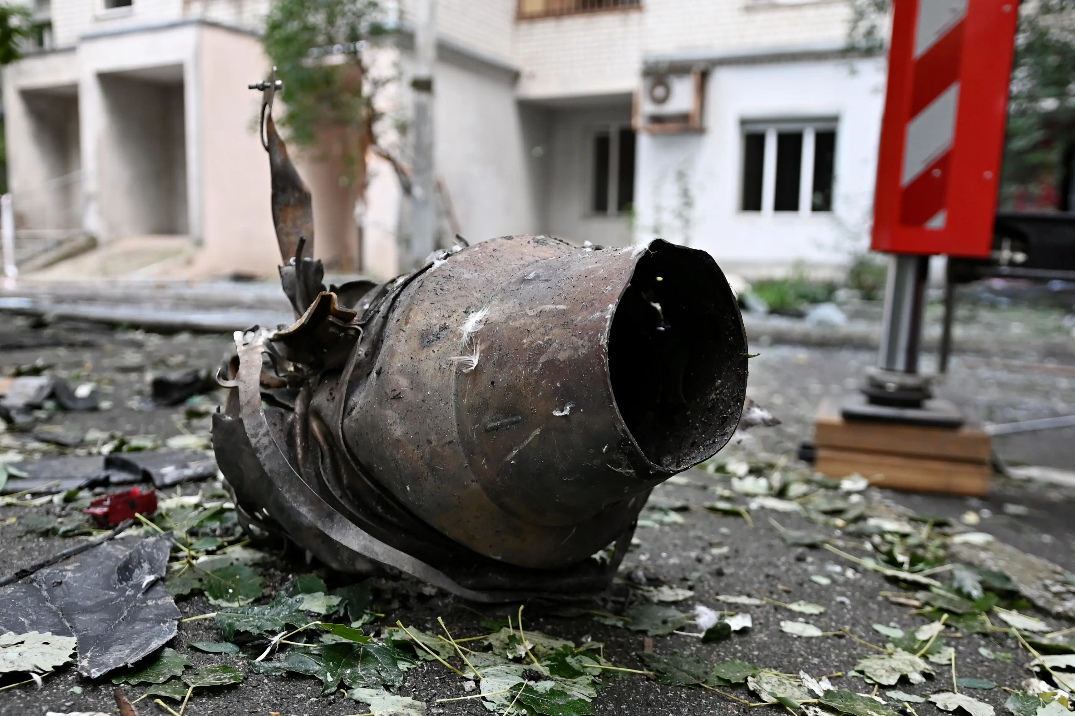 The burnt remains of a Geran-5 turbojet engine lies on the street.