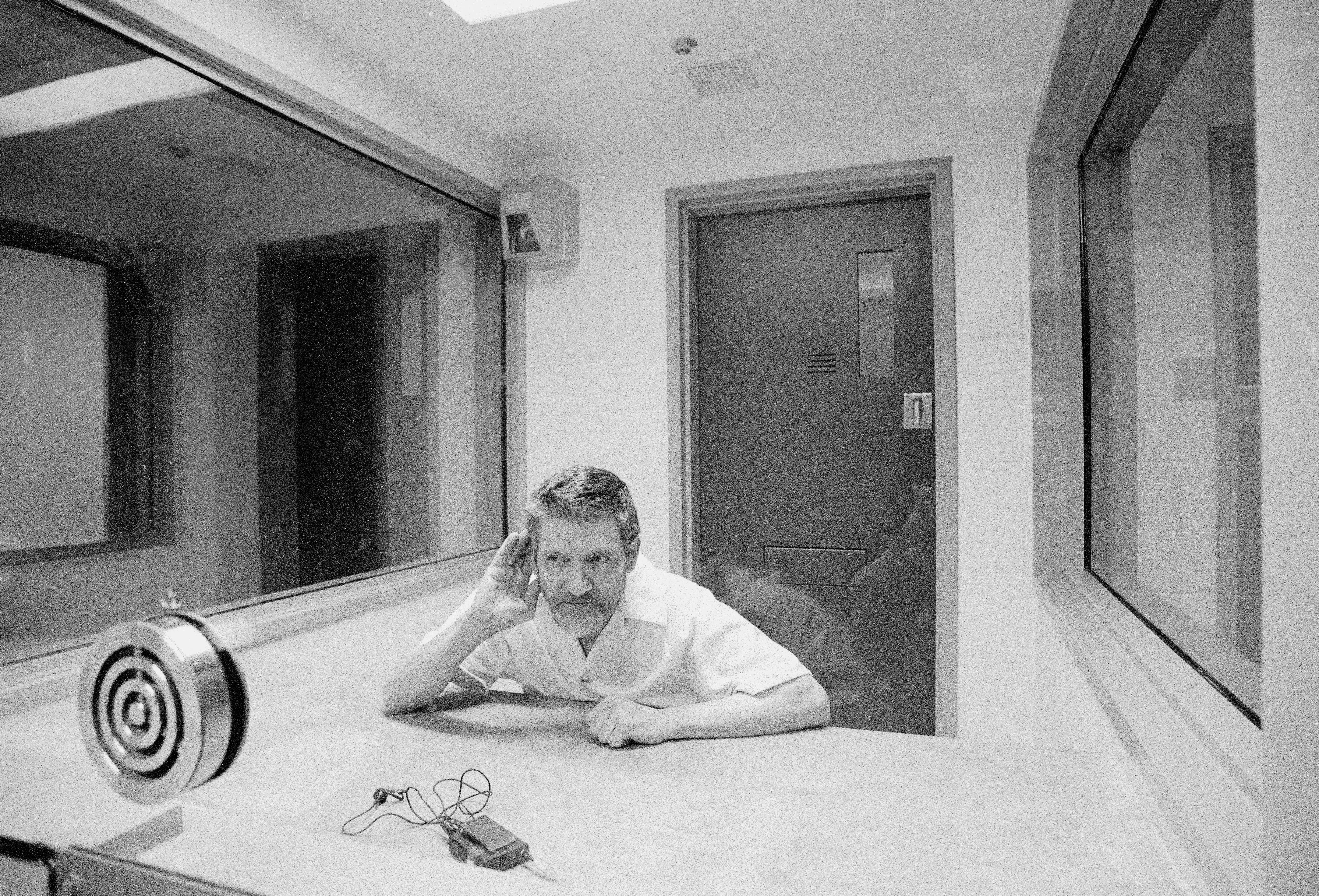 Ted Kaczynski cupping his hand while in a interview room in prison
