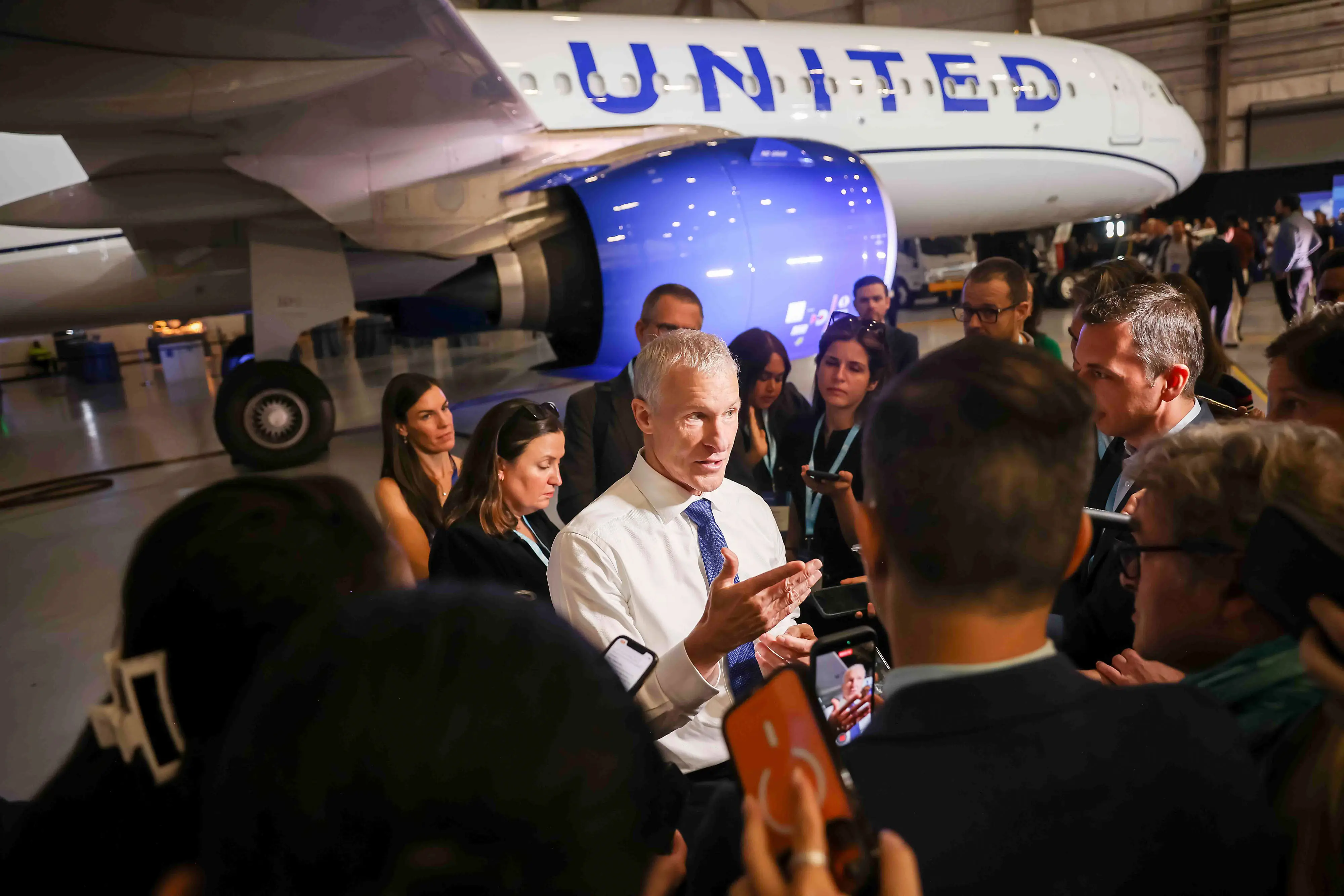 Scott Kirby, chief executive officer at United Airlines Holdings Inc., center, speaks to members of the media during an unveiling event at Newark Liberty International Airport (EWR) in Newark, New Jersey, US, on Tuesday, Aug. 25, 2026. United Airlines Holdings Inc. will add 10 destinations in Europe and Asia to its network next year, deploying Airbus SEs new long-range narrow-body planes to help cash in on demand from Americans looking overseas for leisure.