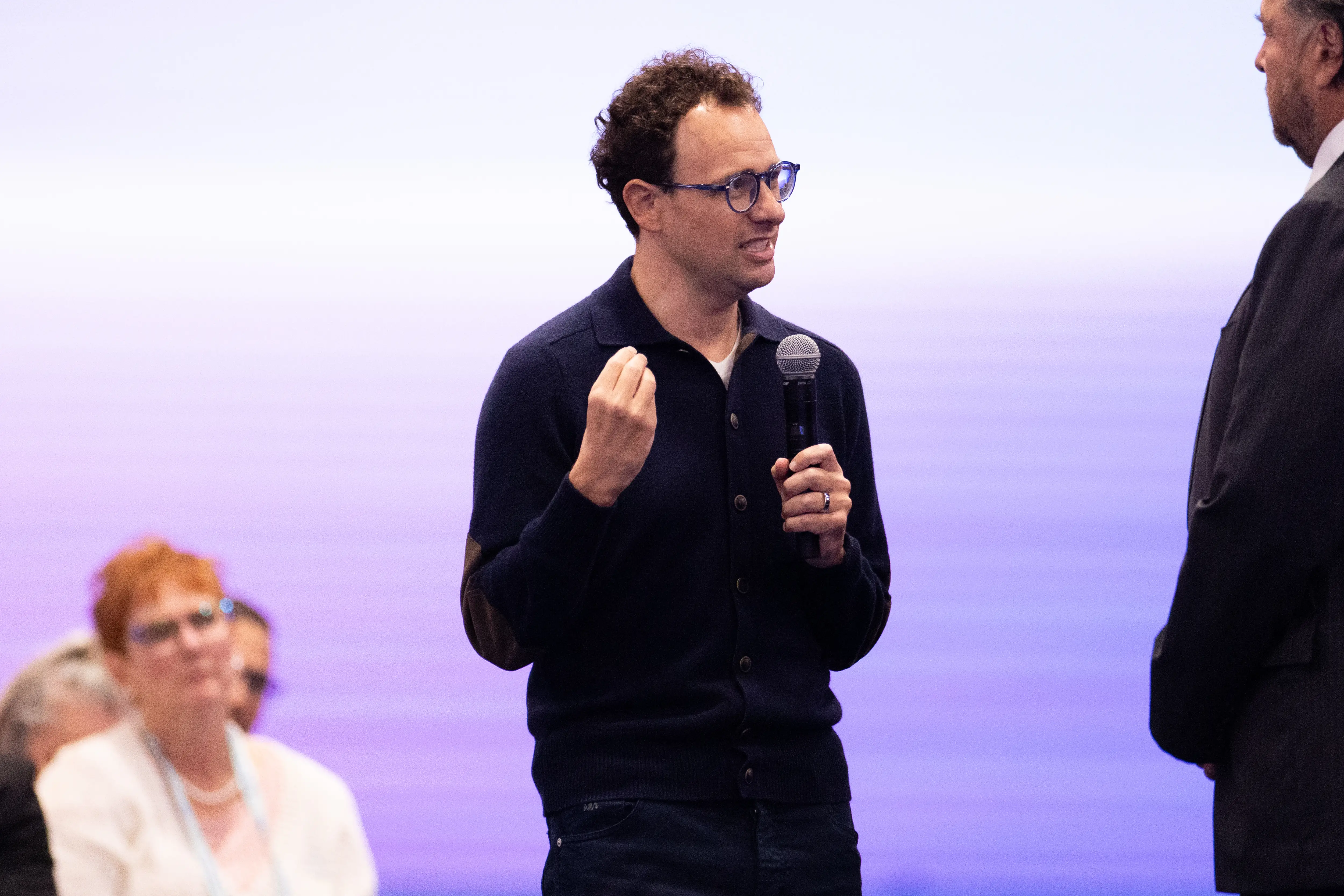 Anthropic CEO Dario Amodei holds a mic while talking during a Salesforce conference.