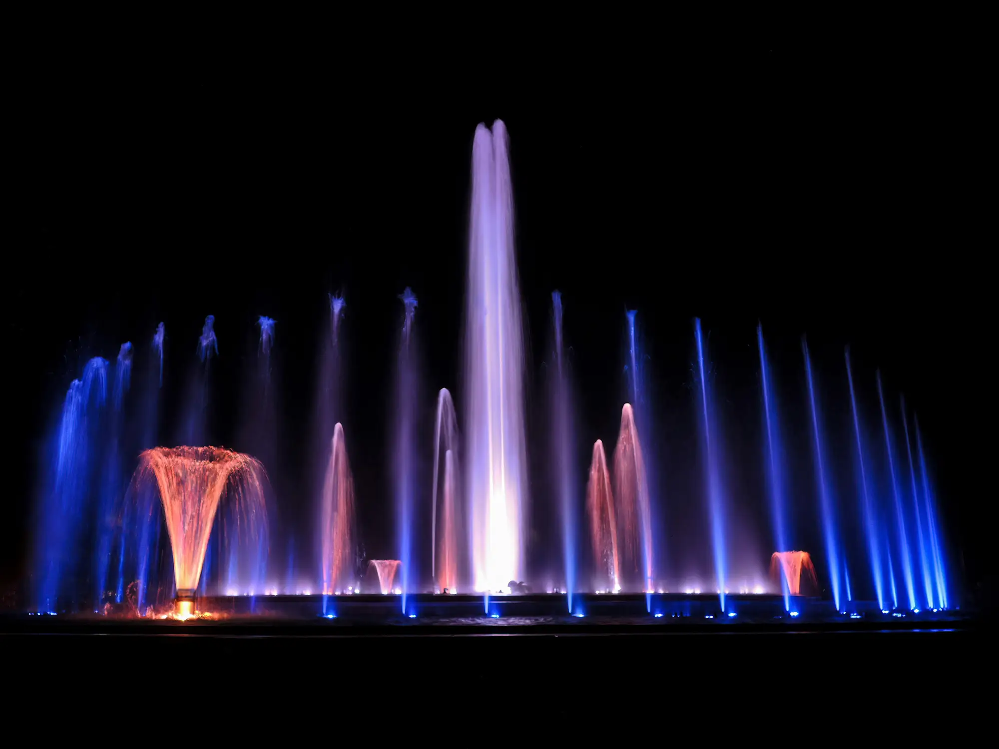A fountain lit up at night.