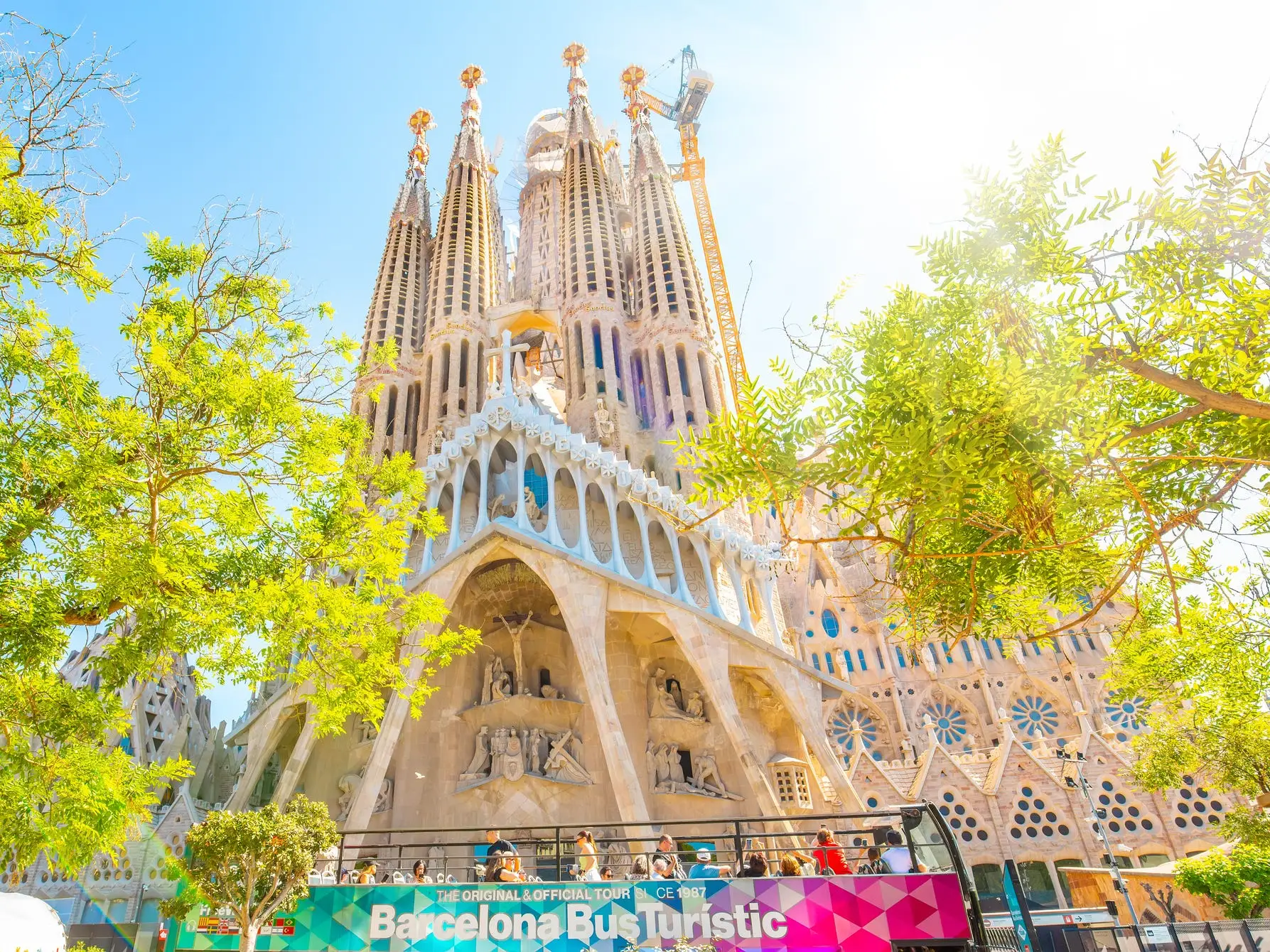 A tourist bus passes by the Sagrada Familia.