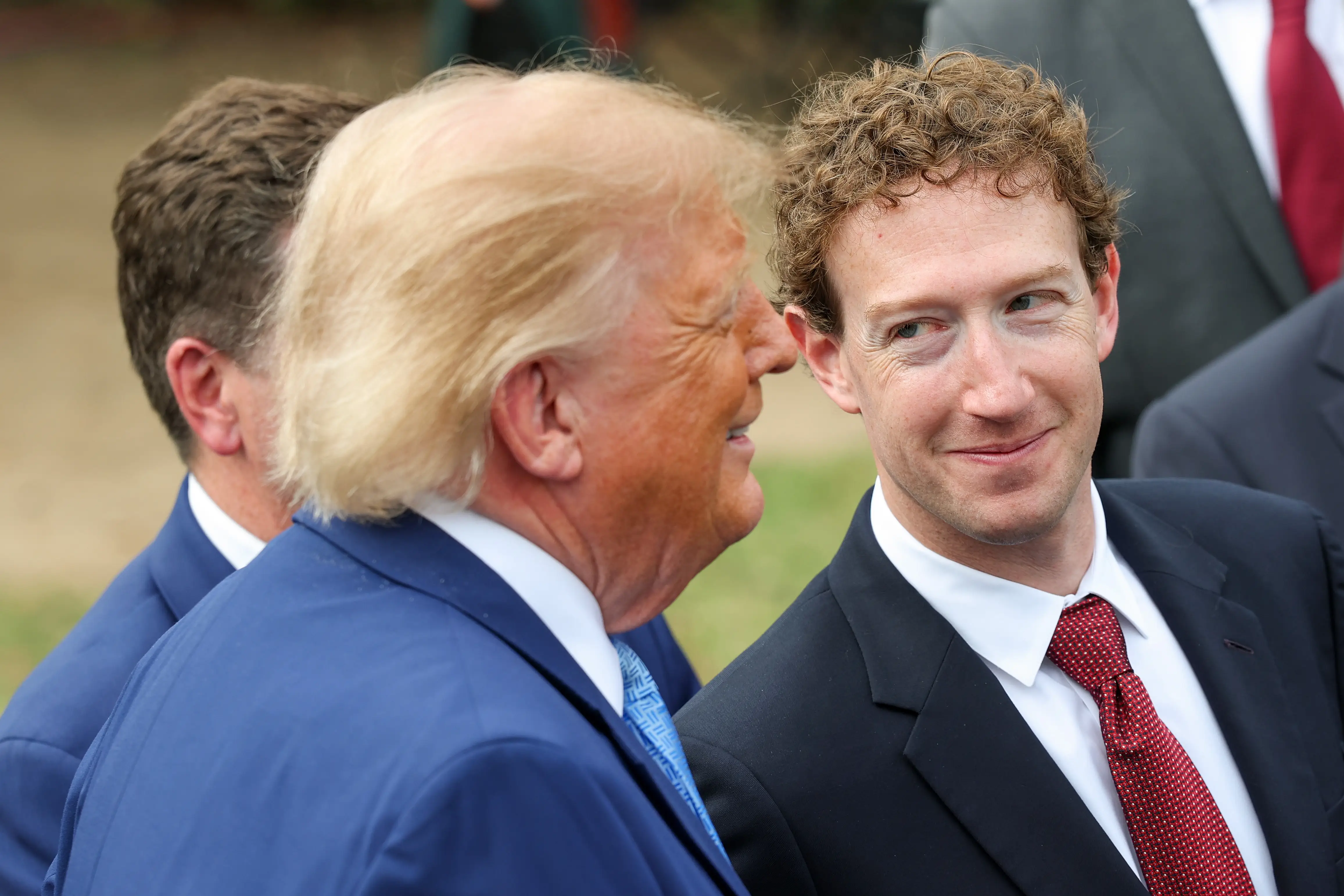 CEO of Meta Platforms Mark Zuckerberg (R) looks at U.S. President Donald Trump