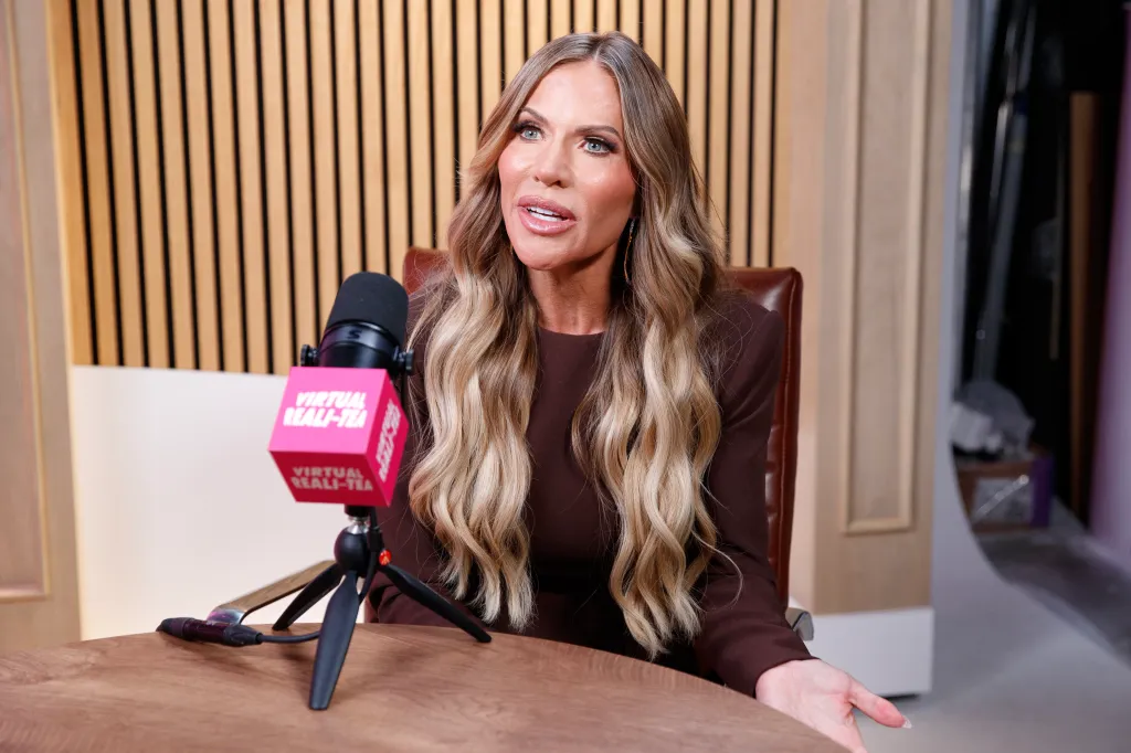 Jenn Pedranti sitting at a table with a microphone in front of her.