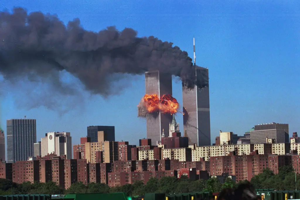 A plane impacts the second World Trade Center tower, creating a large explosion and smoke.