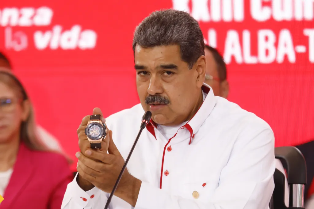 Venezuelan President Nicolas Maduro holding up a Hublot watch while speaking at a press conference.