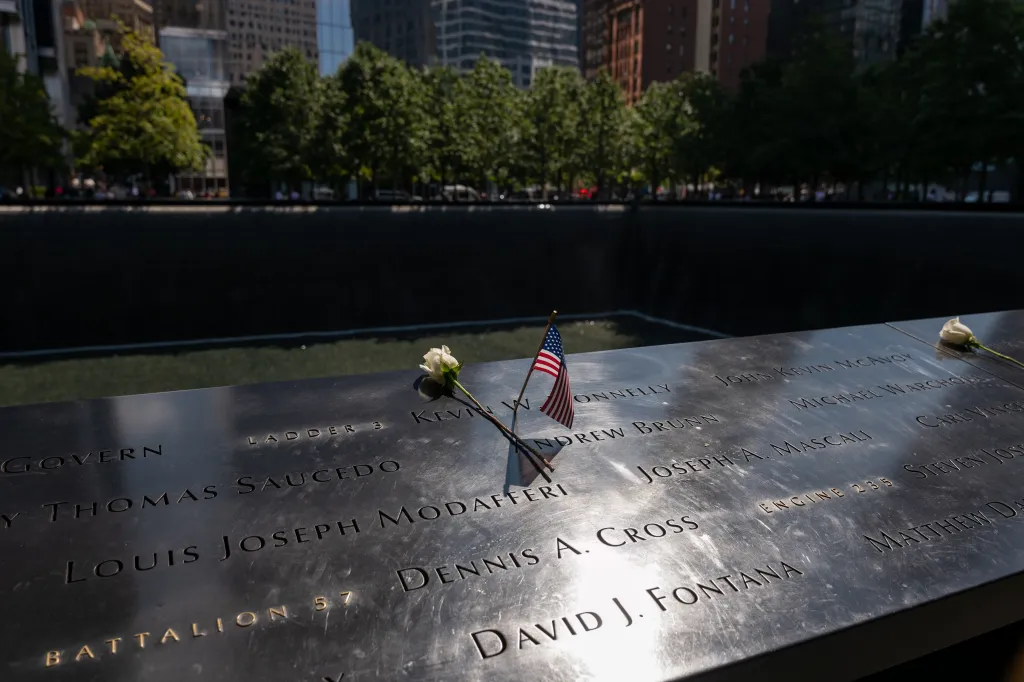A white rose and an American flag placed on the engraved names on the 9/11 Memorial.