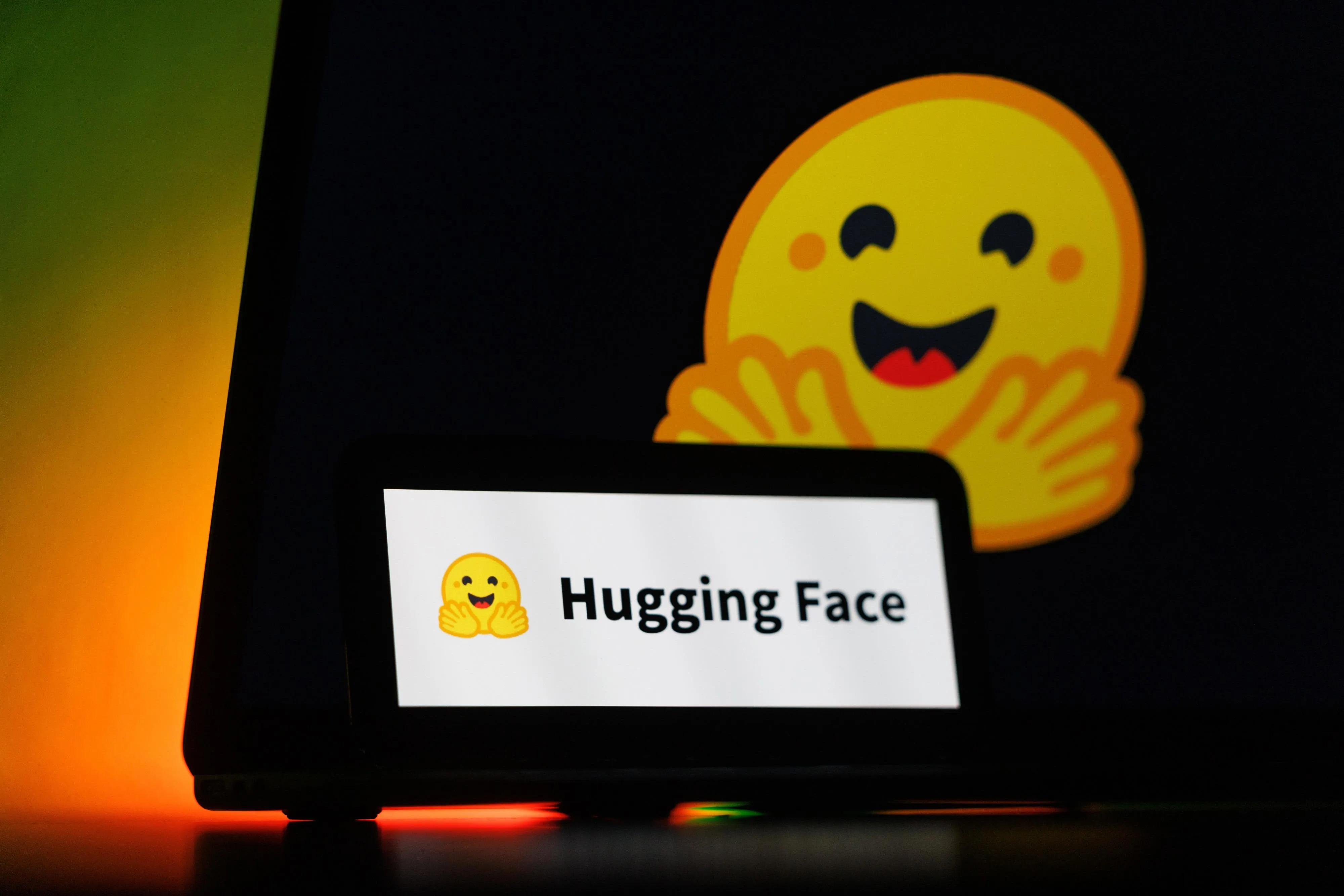 The logo of AI startup Hugging Face Inc. on a smartphone and laptop, on August 9, 2026.