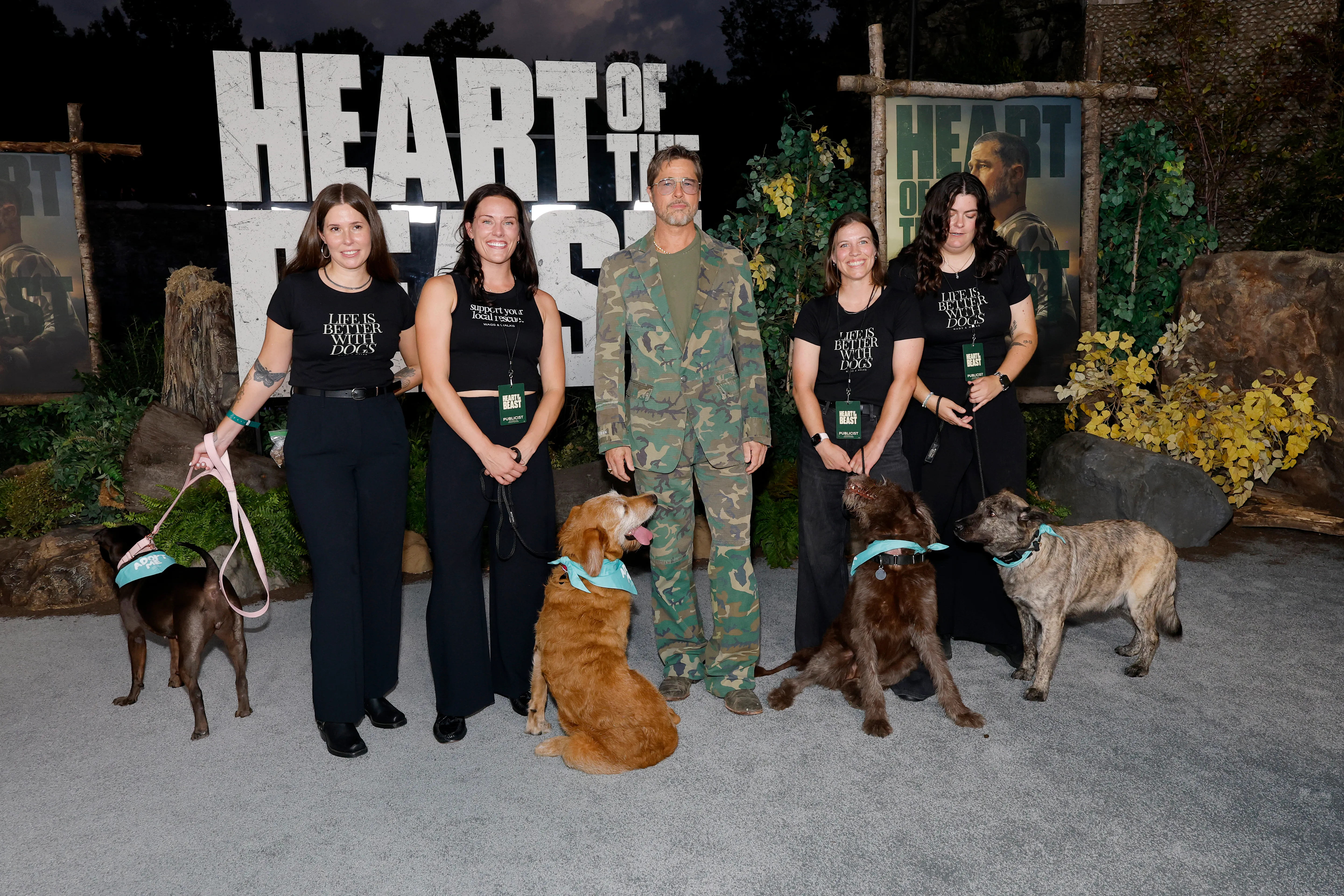 Paramount Pictures' Brad Pitt, four women, and four dogs pose at the