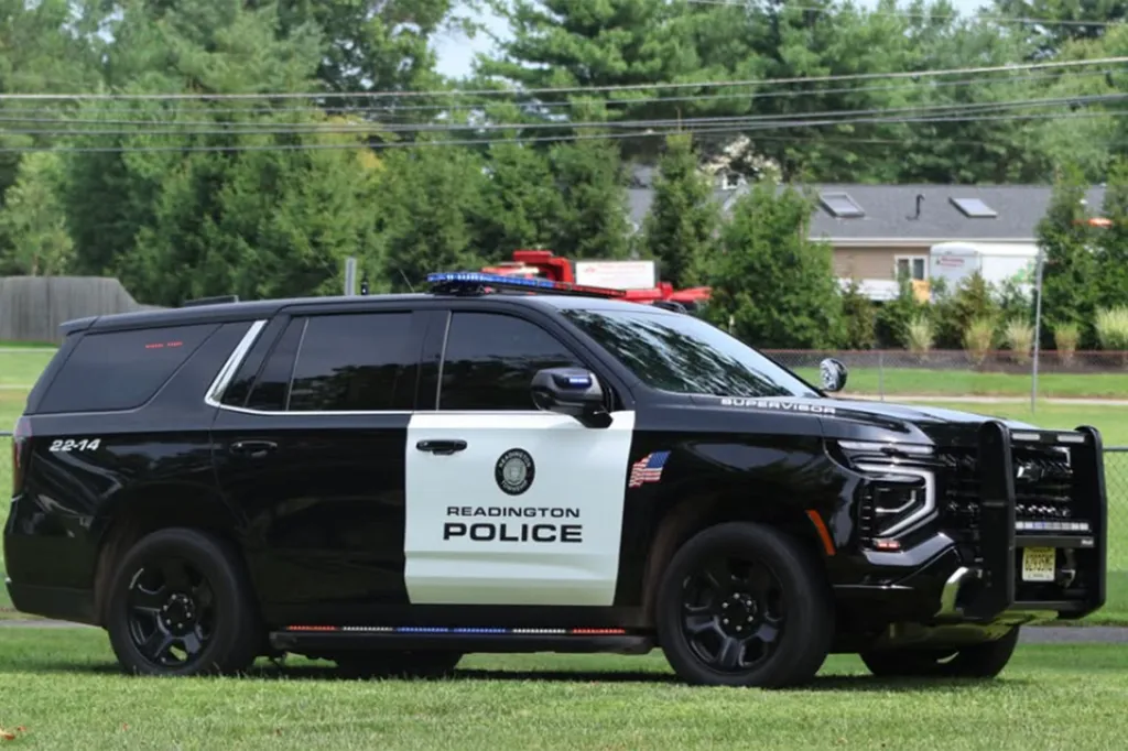 A black and white Readington Police SUV with its light bar on.