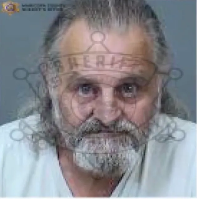 Mugshot of a man with long gray hair and a gray beard.