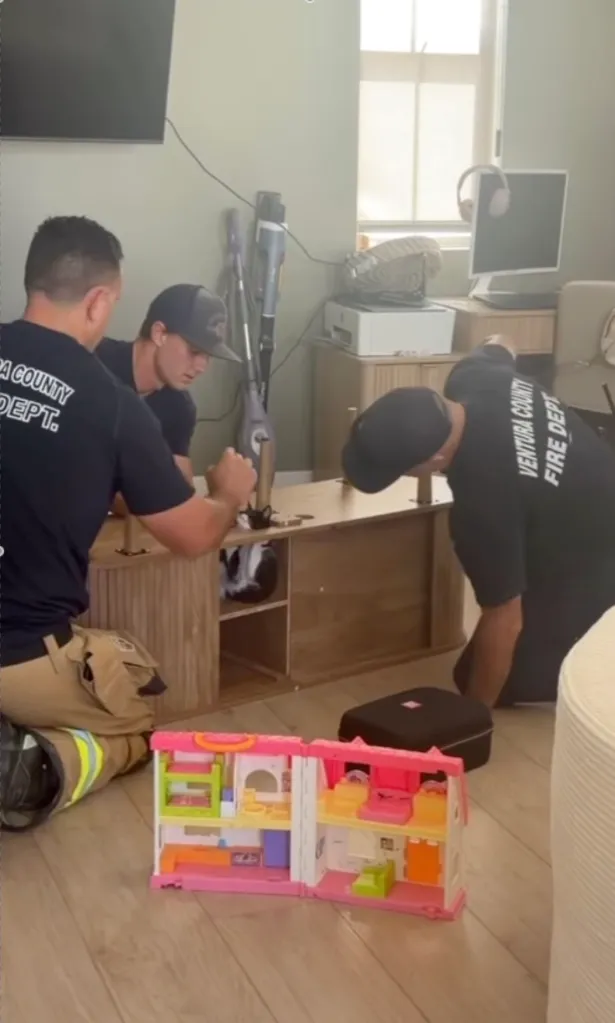 Ventura County Fire Dept. members helping a cat stuck in a media console.