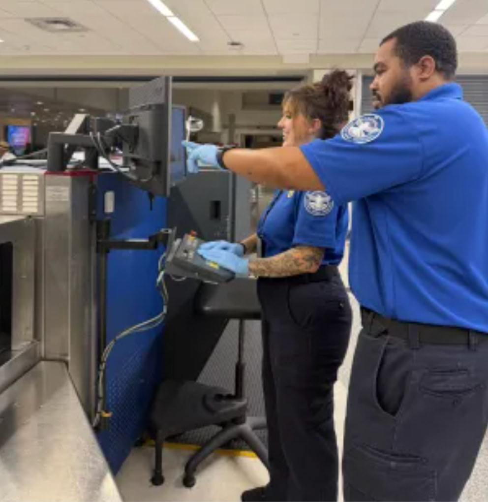 TSA Security Training Instructor Wade Brown Jr. and TSA Officer Jazmine Kramer examine the X-ray monitor to review the image of the suspicious item.