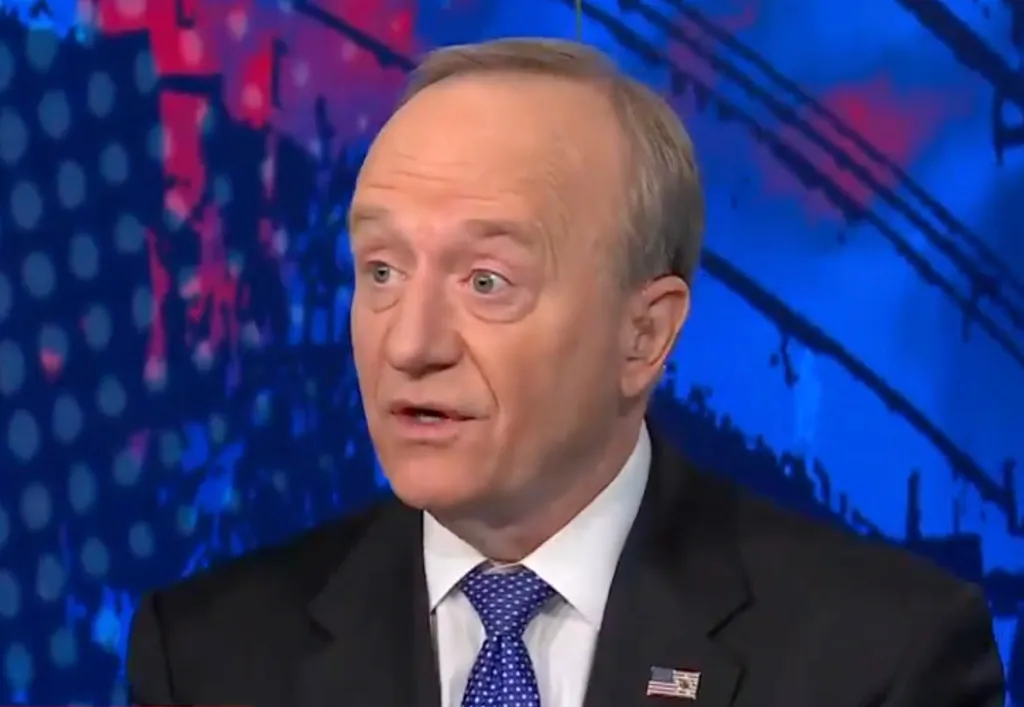A man in a suit and tie speaking.
