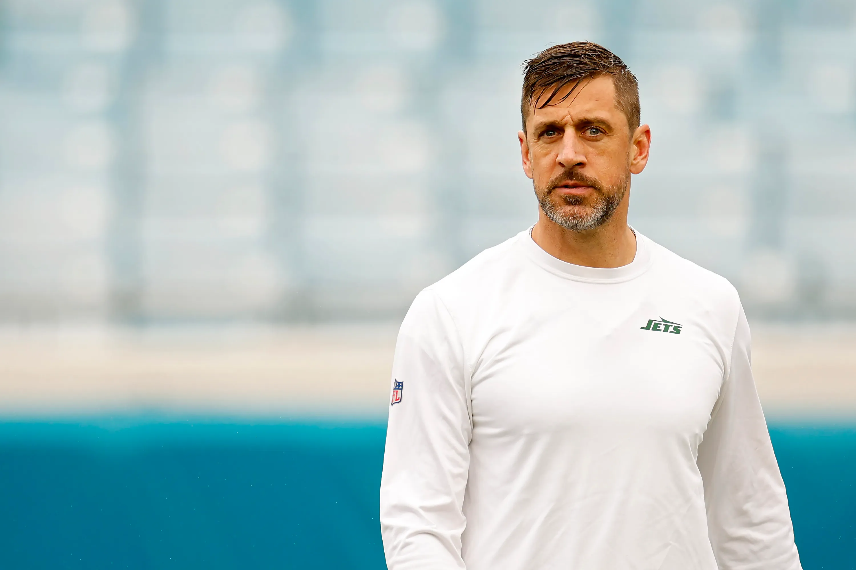 Aaron Rodgers #8 of the New York Jets in a white long-sleeved shirt with 