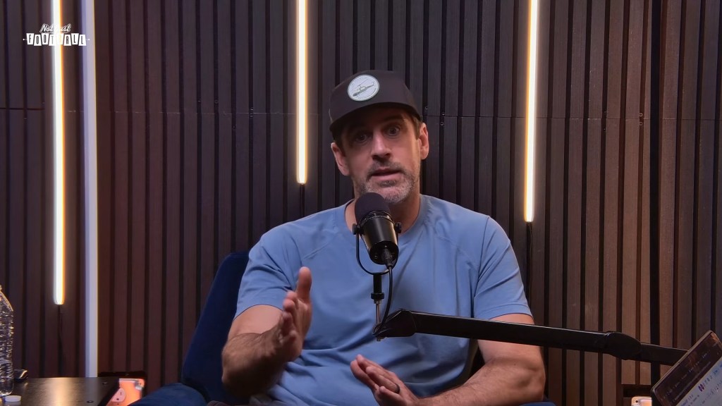Aaron Rodgers speaking into a microphone.