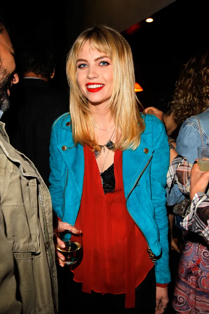 Actress Daveigh Chase smiling while holding a drink at a dinner event.