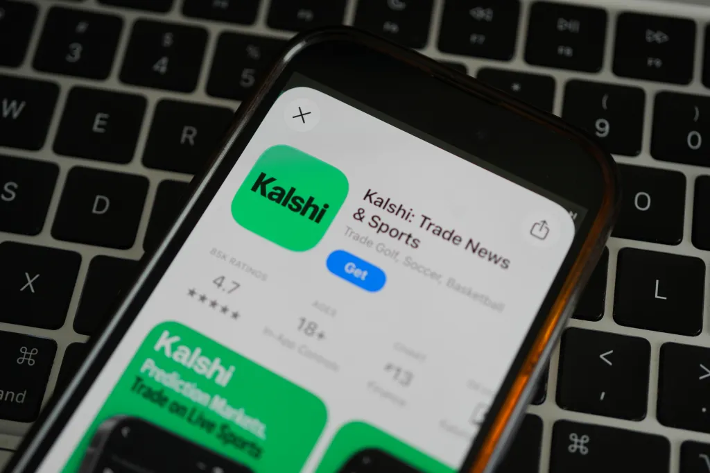 A mobile phone displaying the Kalshi prediction market app on a keyboard.